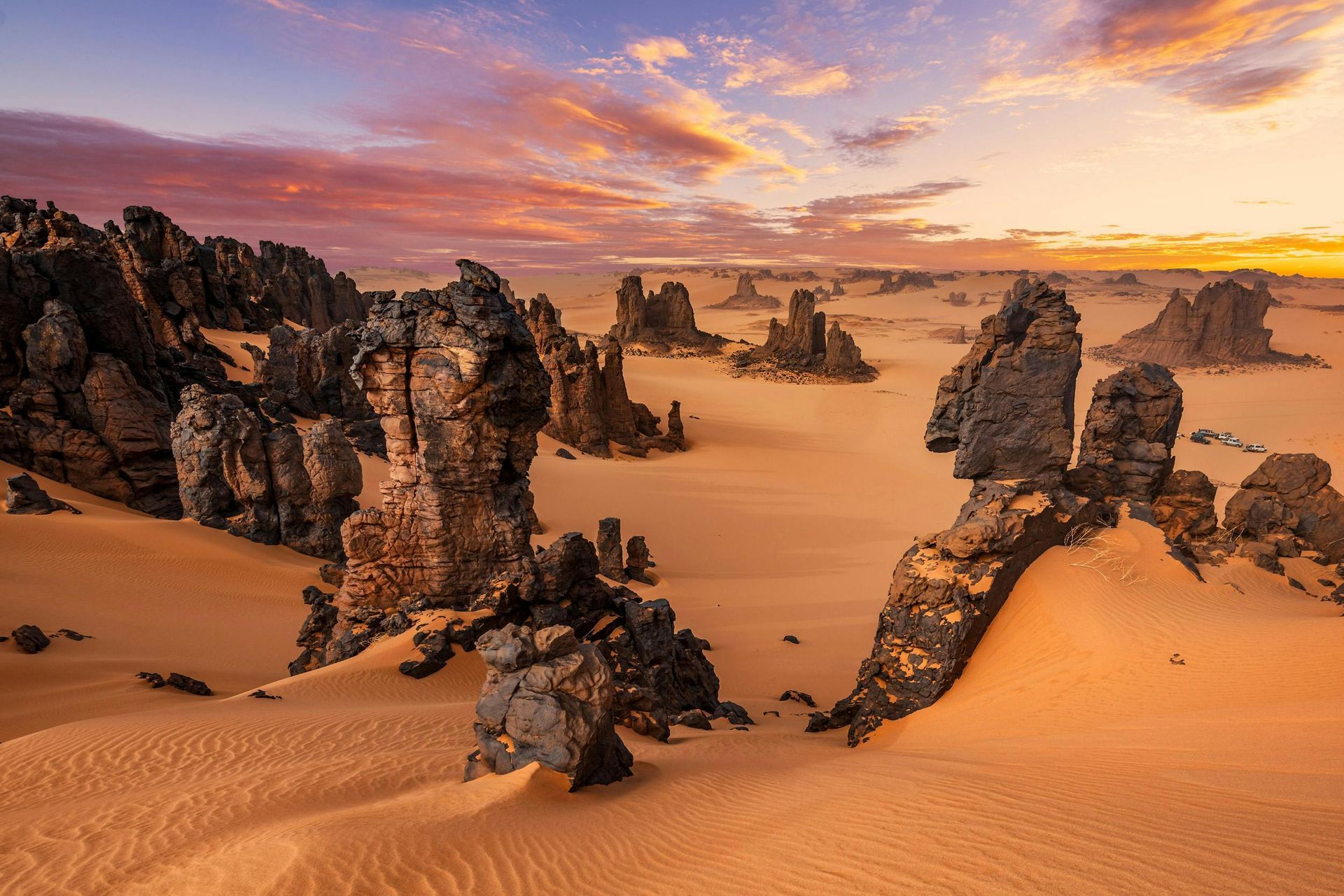 A desert landscape with rocks and sand at sunset