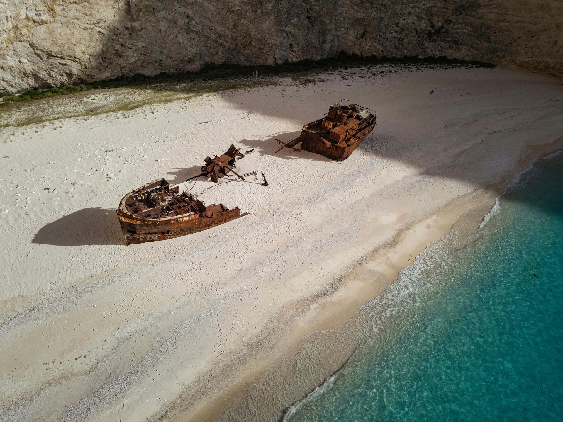 An aerial view of a shipwreck on a sandy beach.