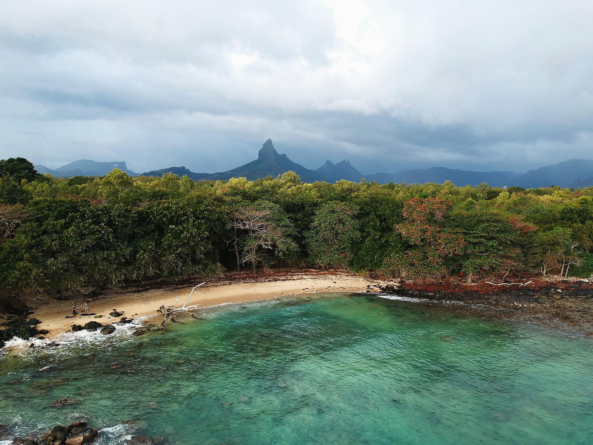An aerial view of a beach with mountains in the background