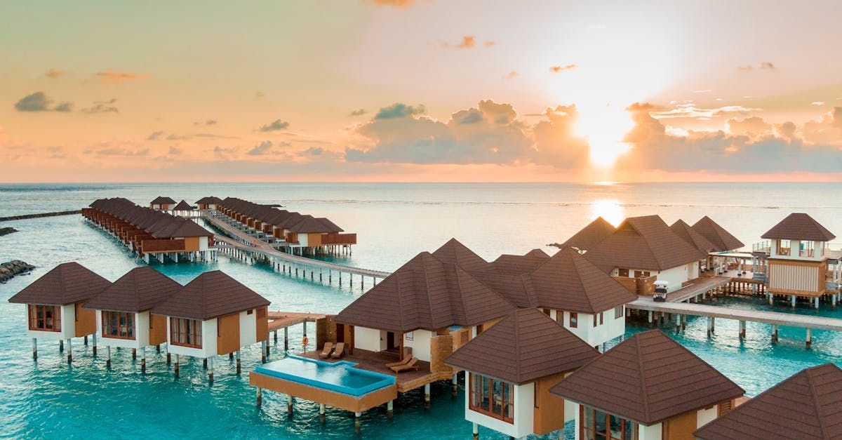 An aerial view of a resort in the middle of the ocean at sunset in Maldives