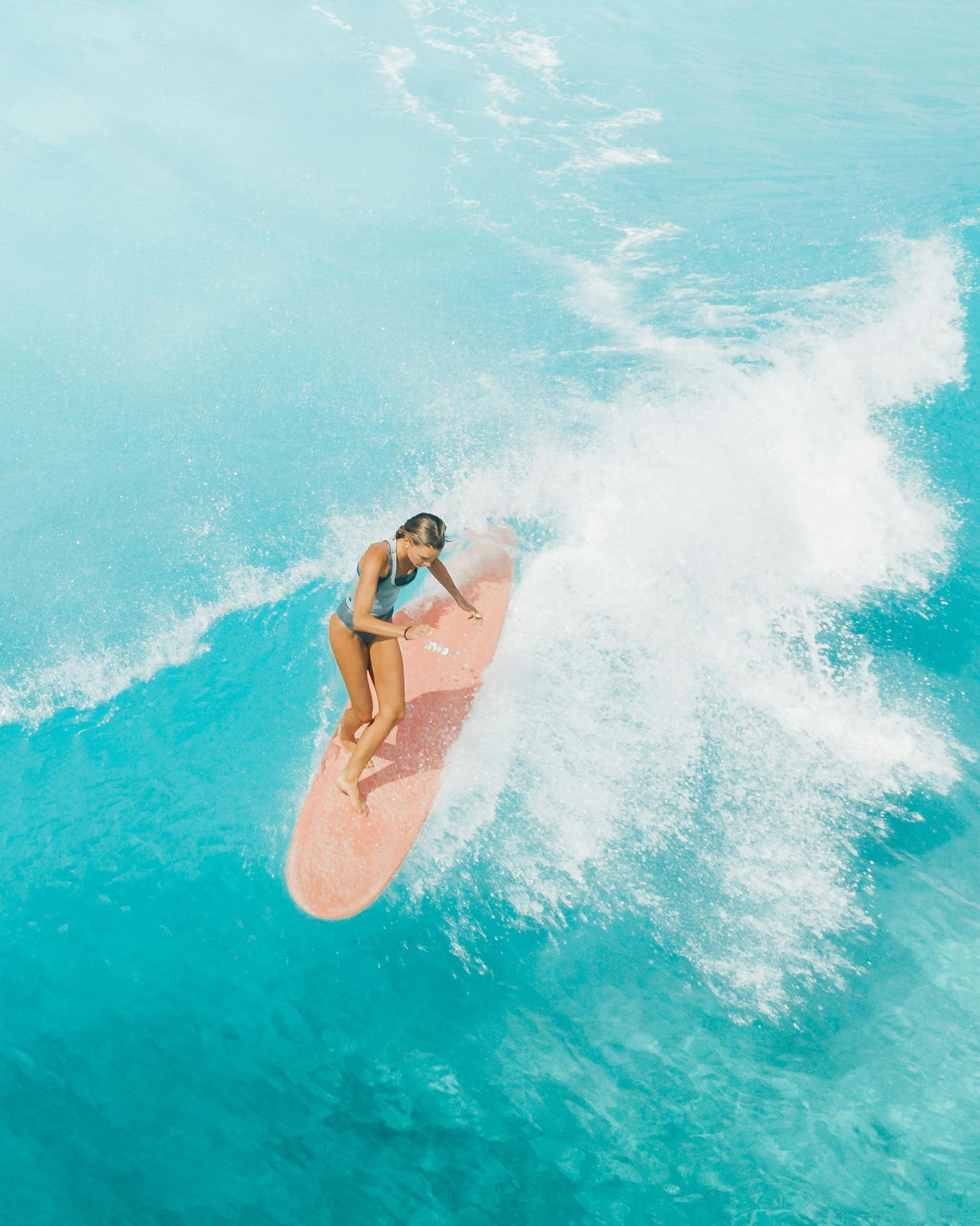 A woman is riding a wave on a surfboard in the ocean.