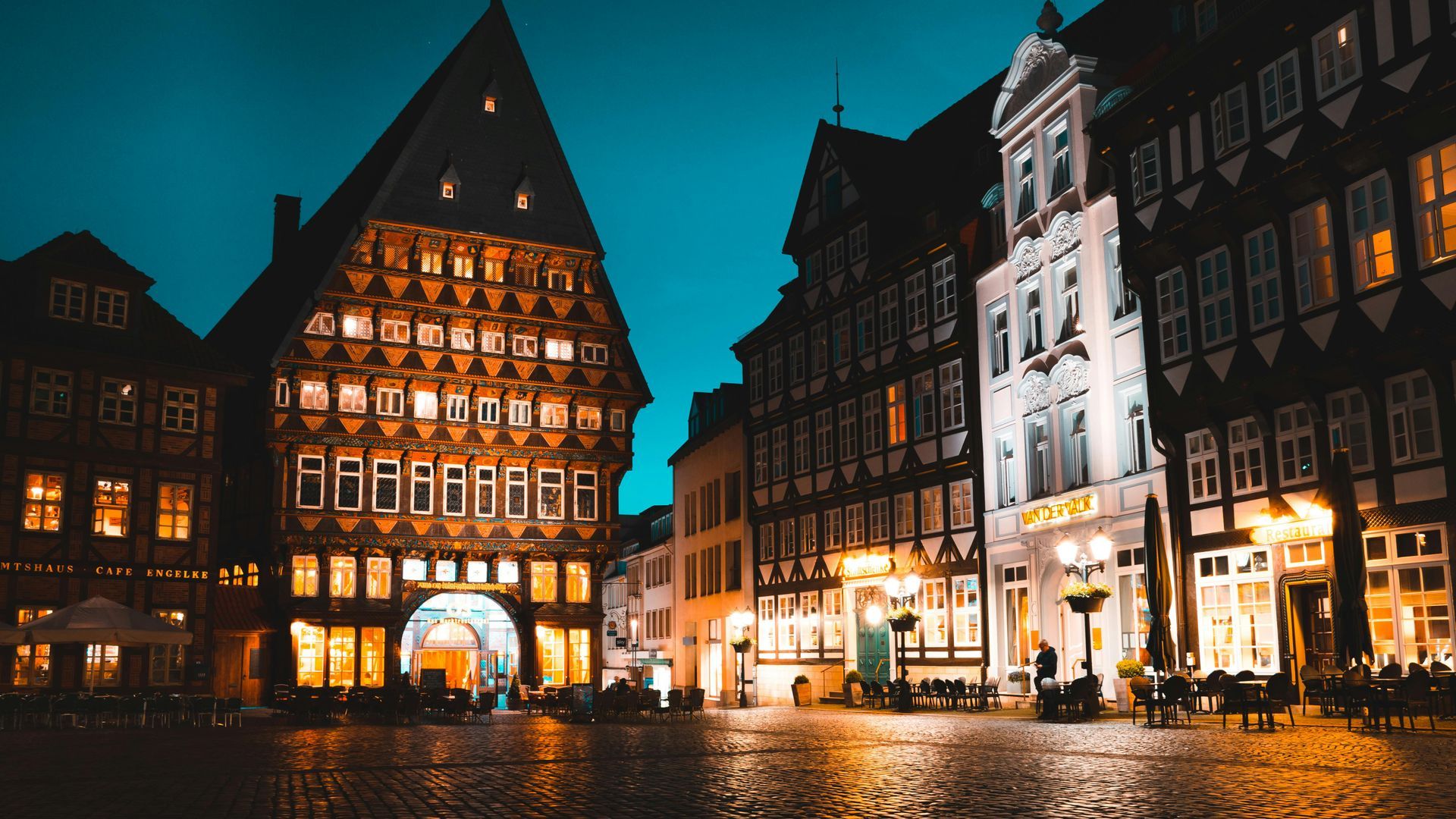 A row of buildings are lit up at night in the city of Munich