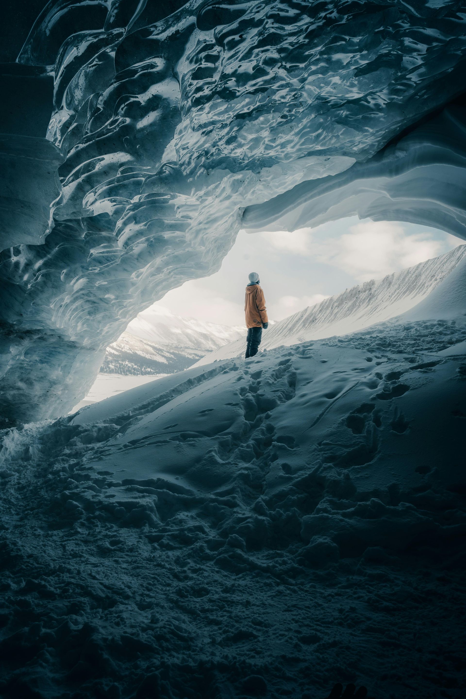 A man is standing in the middle of an ice cave in Canada