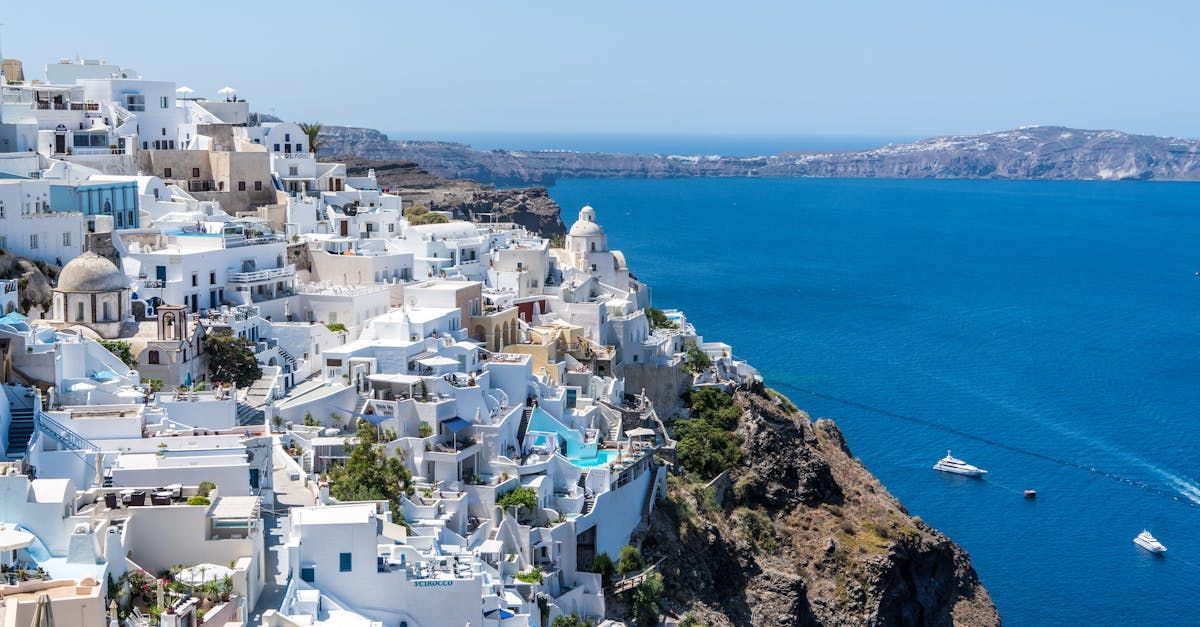 An aerial view of a small town on a cliff overlooking the ocean.