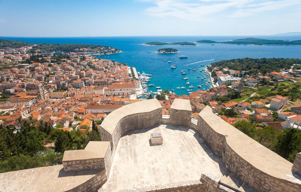 An aerial view of Split city with a castle in the foreground and a body of water in the background.