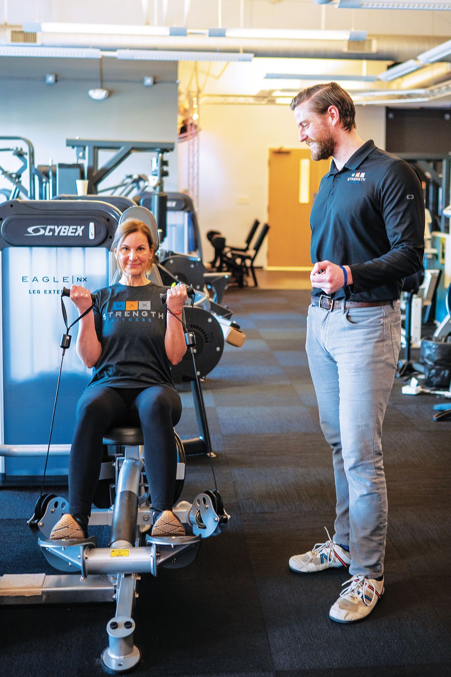 A pair of hands holds a white, open-top container filled with vibrant orange and purple flower buds.