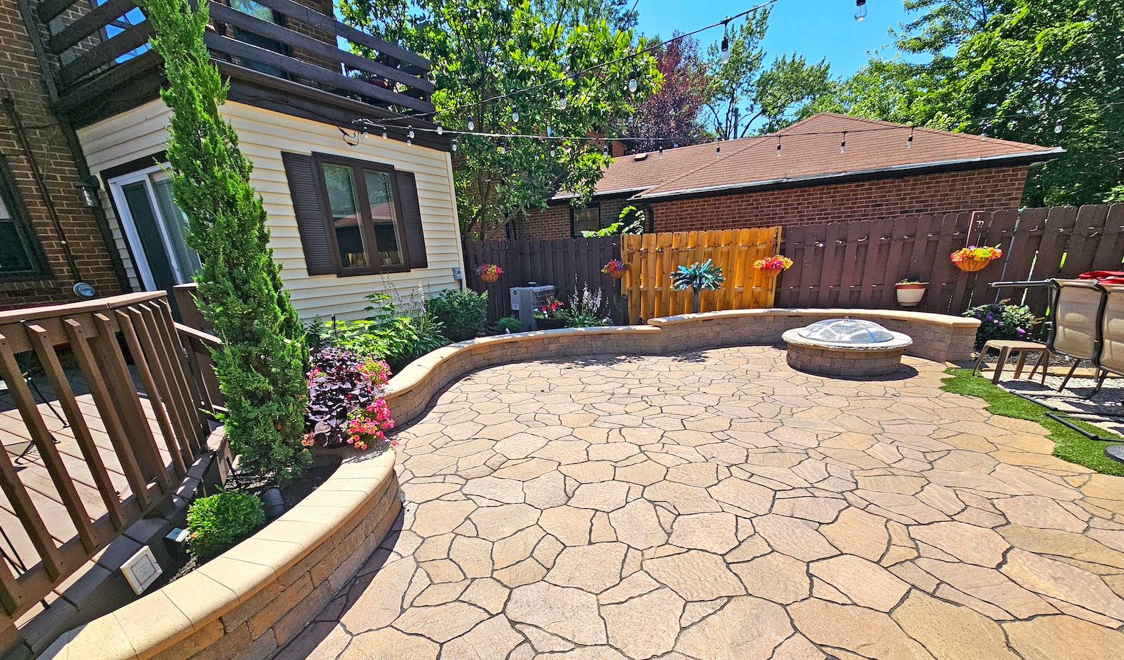 A stack of books sits on a wooden table, next to a lit candle and a warm cup of coffee or tea.