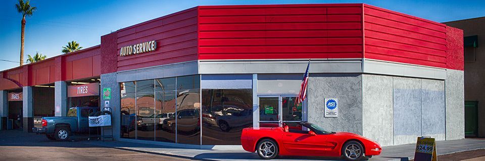 A red sports car is parked in front of a car dealership. | 19th Avenue Garage