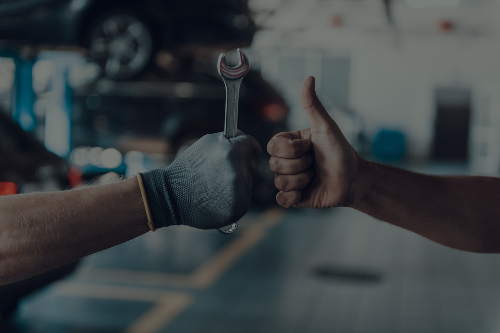 A man is holding a wrench in his hand and giving a thumbs up. | 19th Avenue Garage