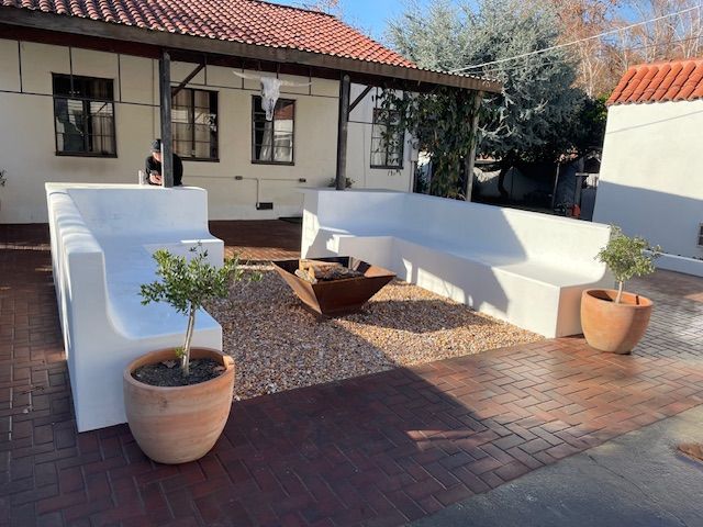 A patio with white furniture and potted plants