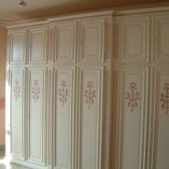 Armadio in legno bianco con decorazioni floreali.