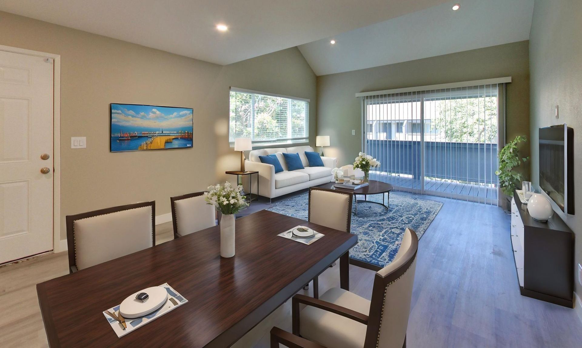 modern living room with a sofa, coffee table, bench, chair, tv and onlooking to a patio
