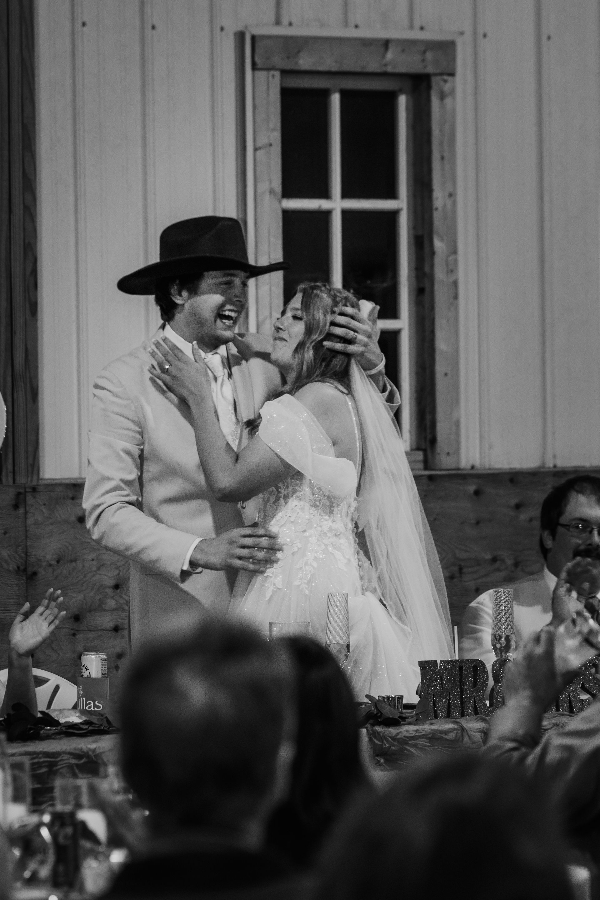 A black and white photo of a bride and groom toasting at their wedding reception.