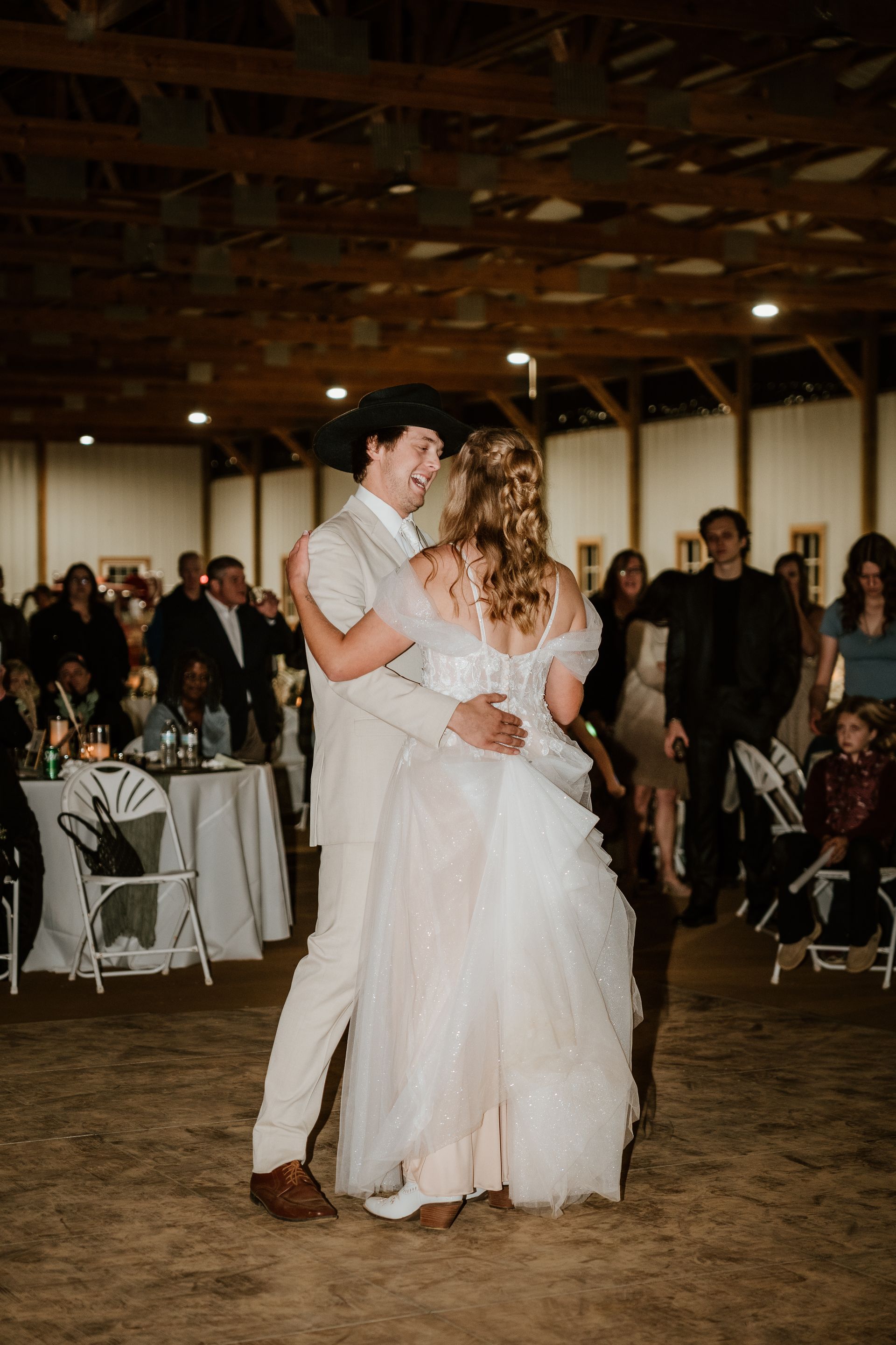 A bride and groom are dancing at their wedding reception.