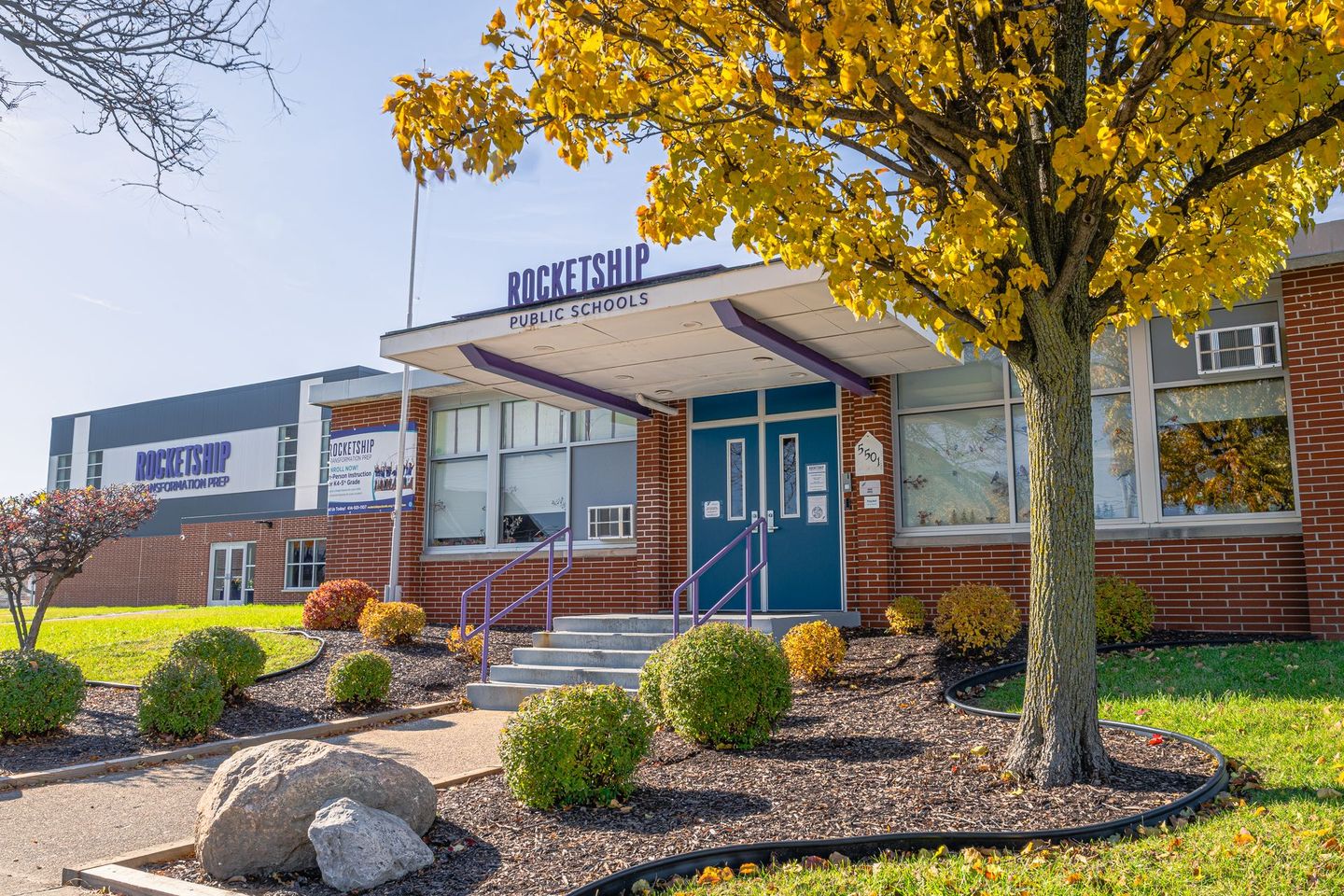 The front of a school building with a tree in front of it.