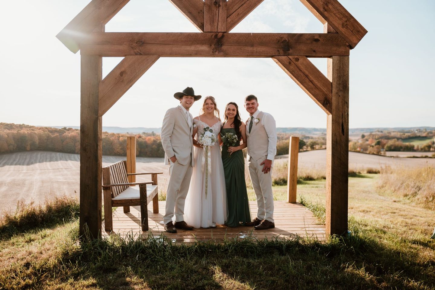 A group of people are posing for a picture under a wooden structure.