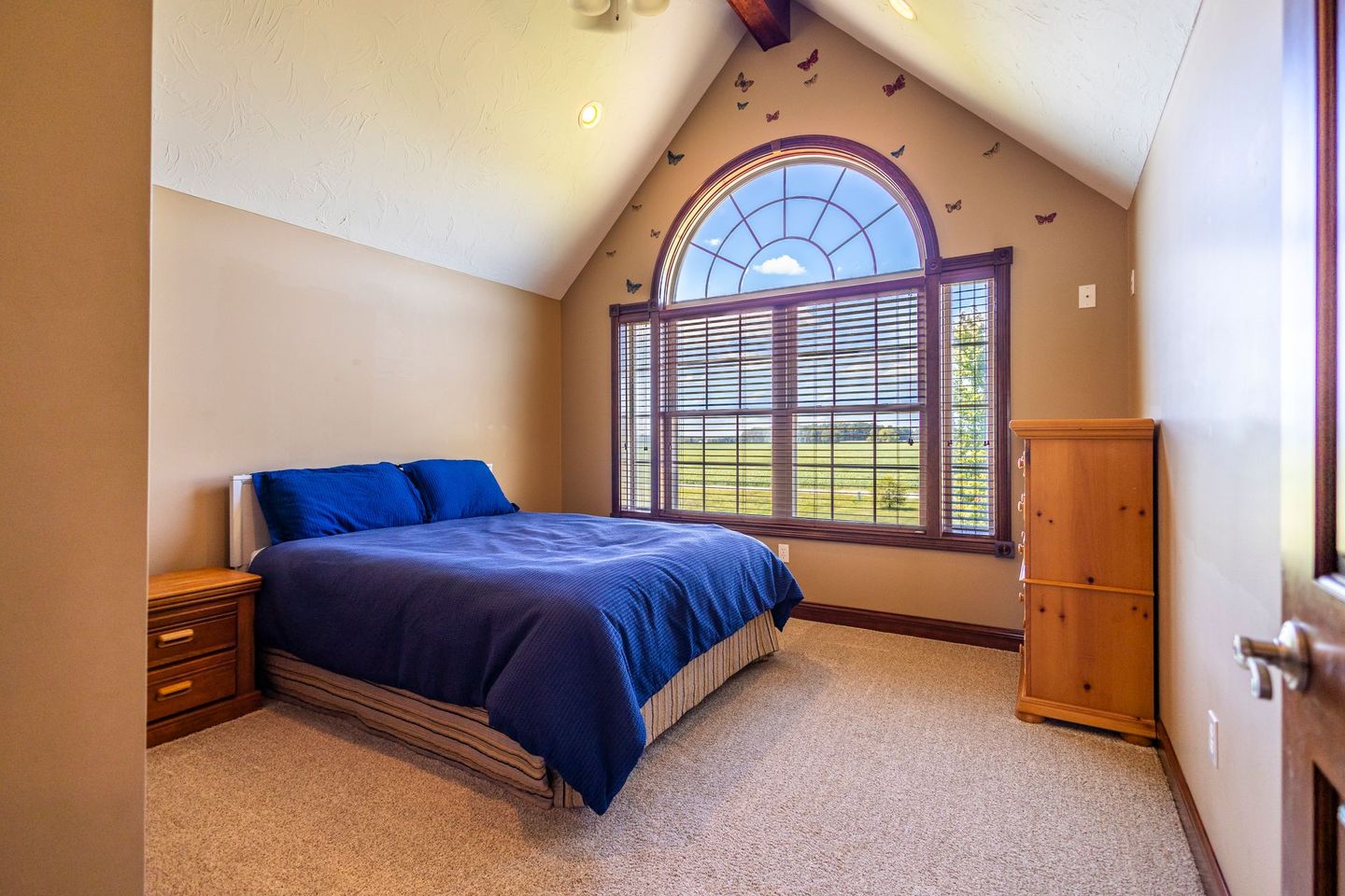 A bedroom with a king size bed and a large window.