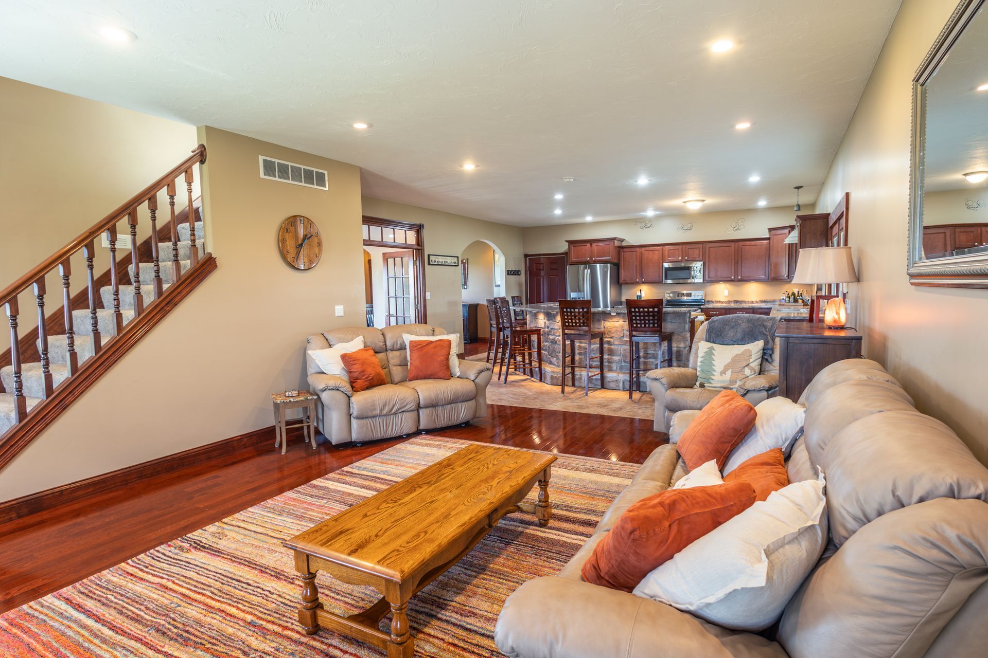 A living room with a couch , coffee table , chairs and stairs.