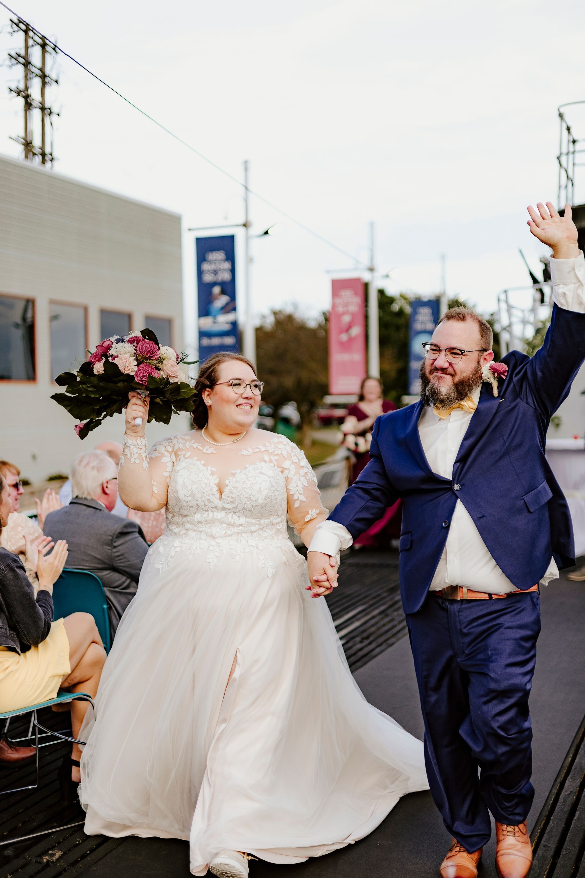 A bride and groom are walking down the aisle at their wedding holding hands.