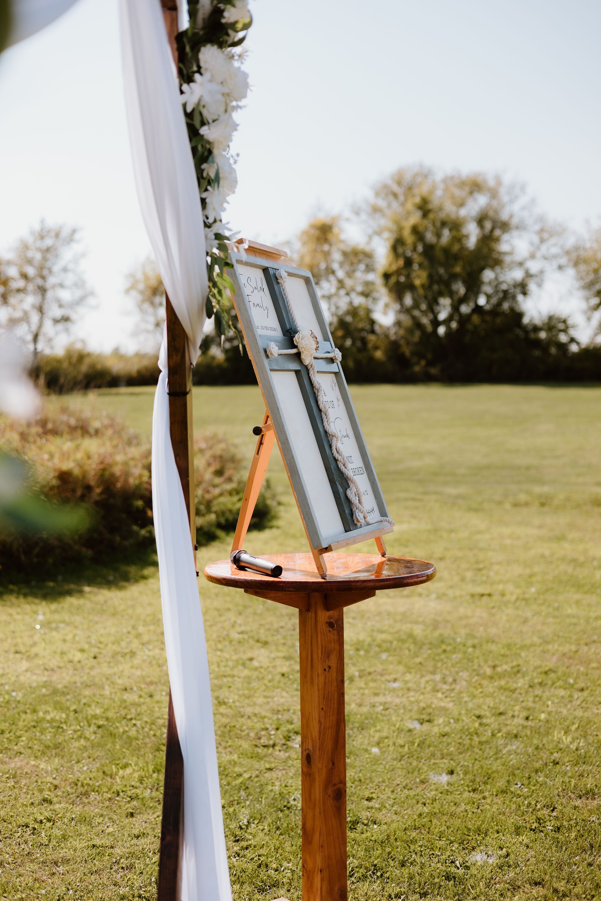 A wooden easel with a sign on it in a field.
