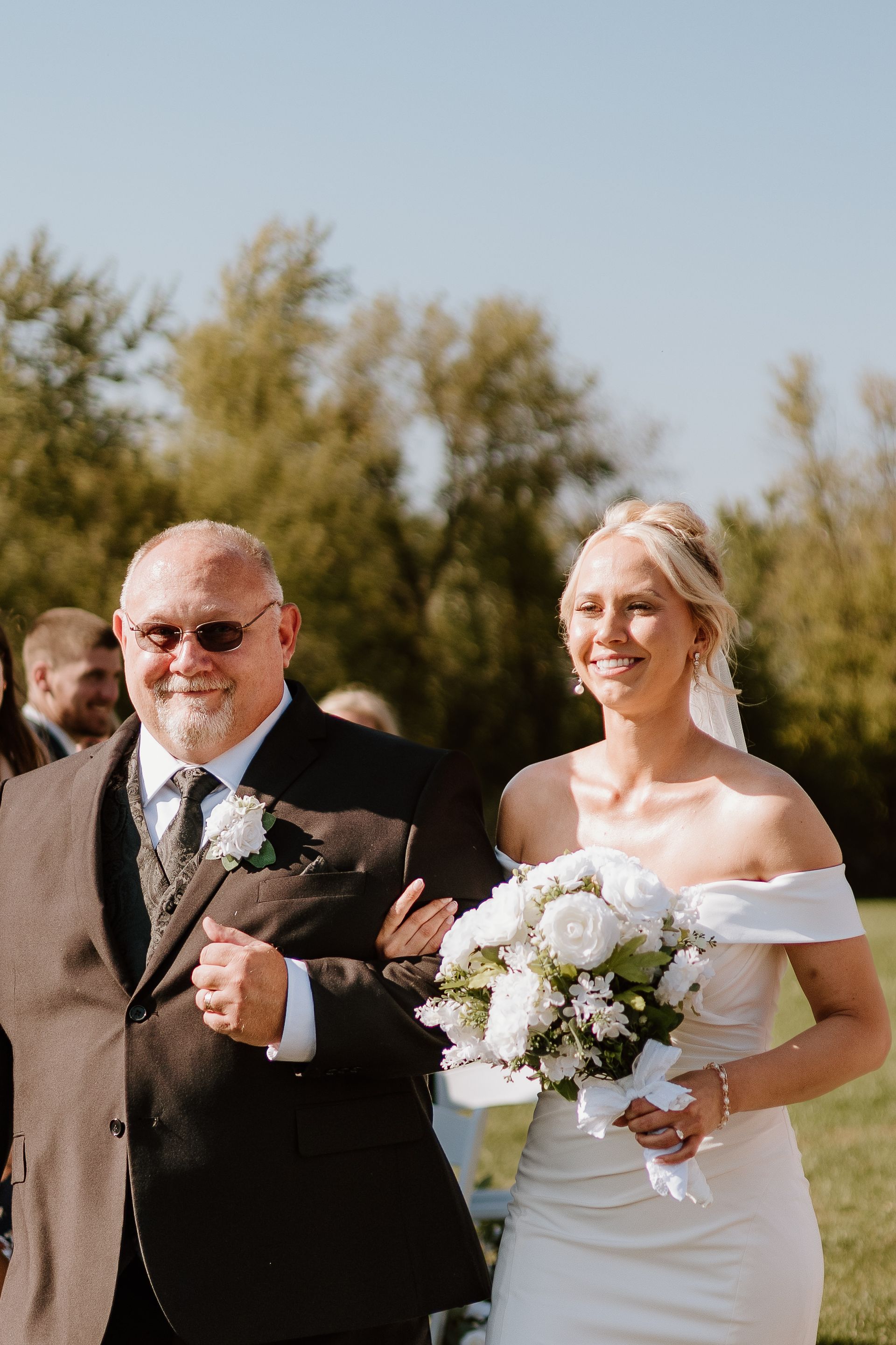 A bride is walking down the aisle with her father.