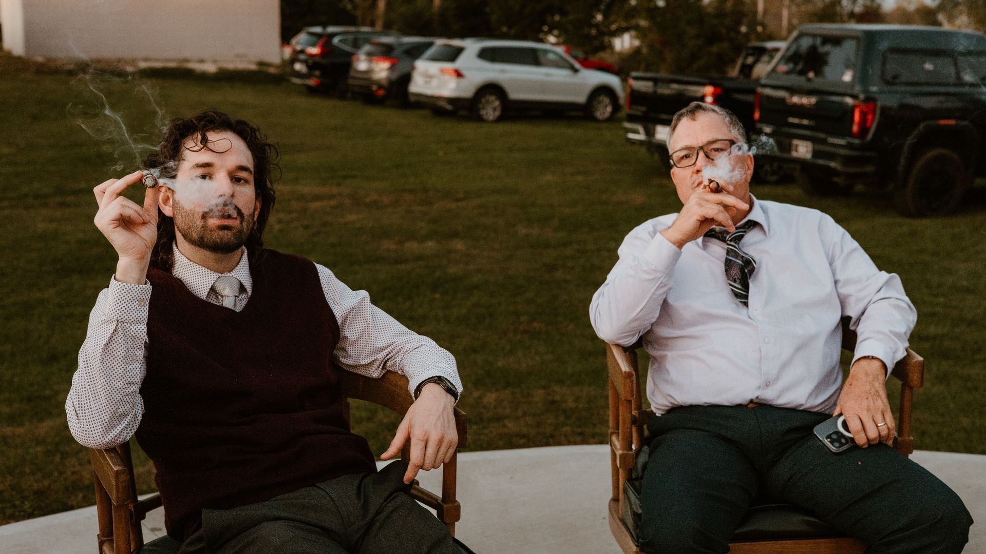 two men are smoking cigars sitting down