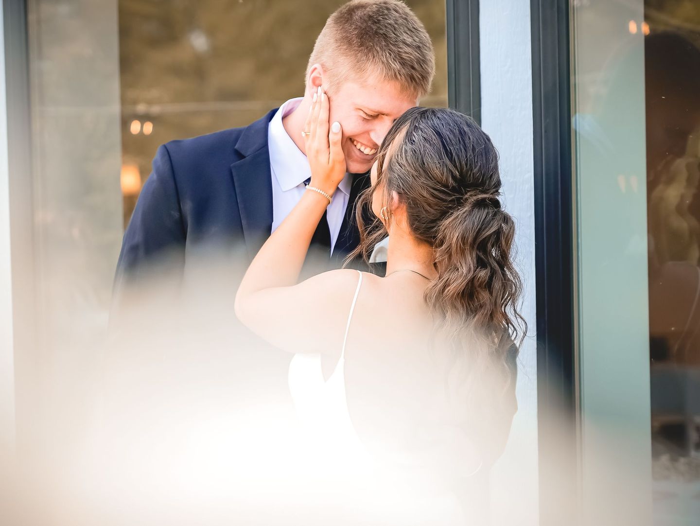 A bride and groom are looking into each other 's eyes.