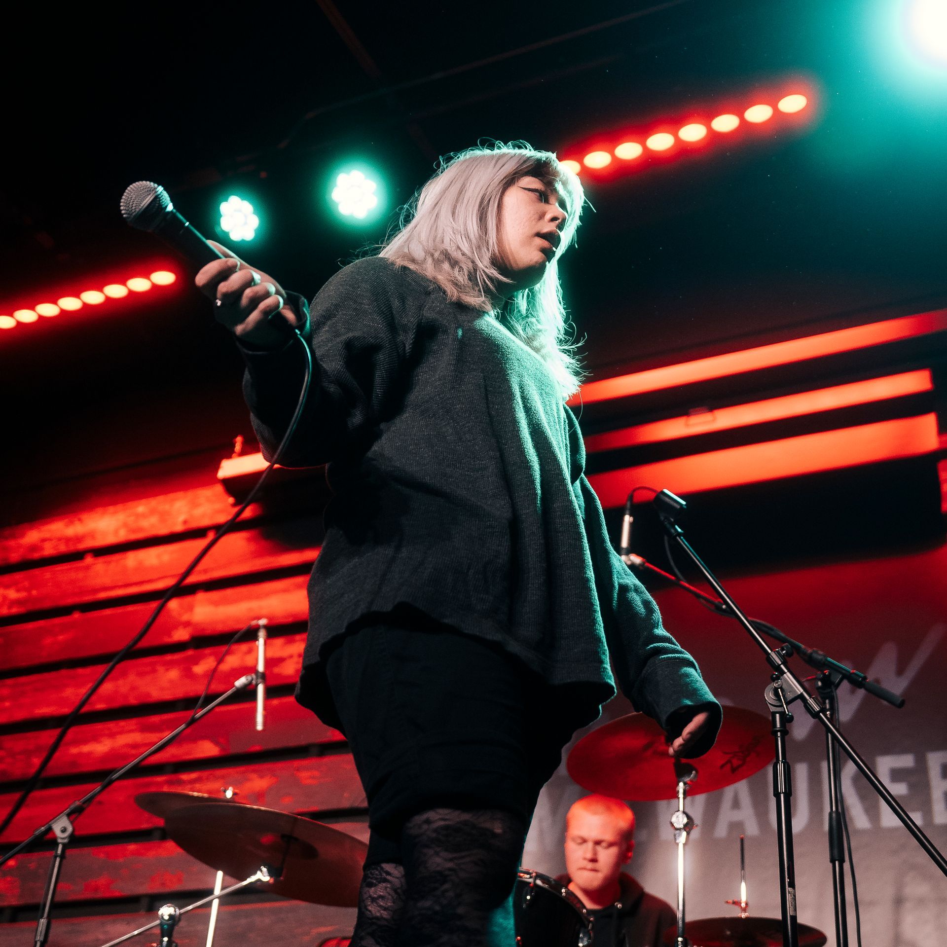 A woman singing into a microphone on a stage