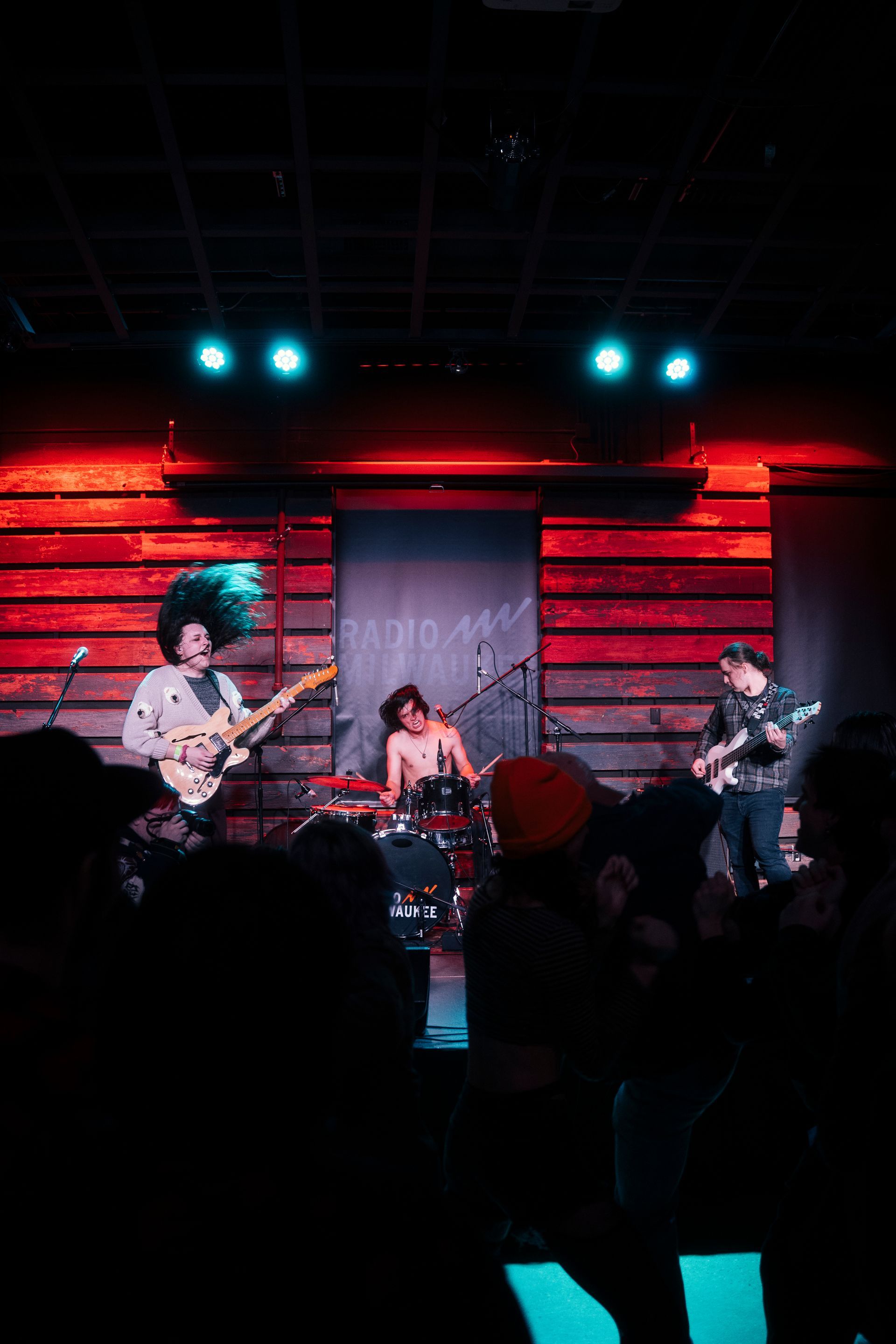 A group of people are playing instruments on a stage in front of a crowd.