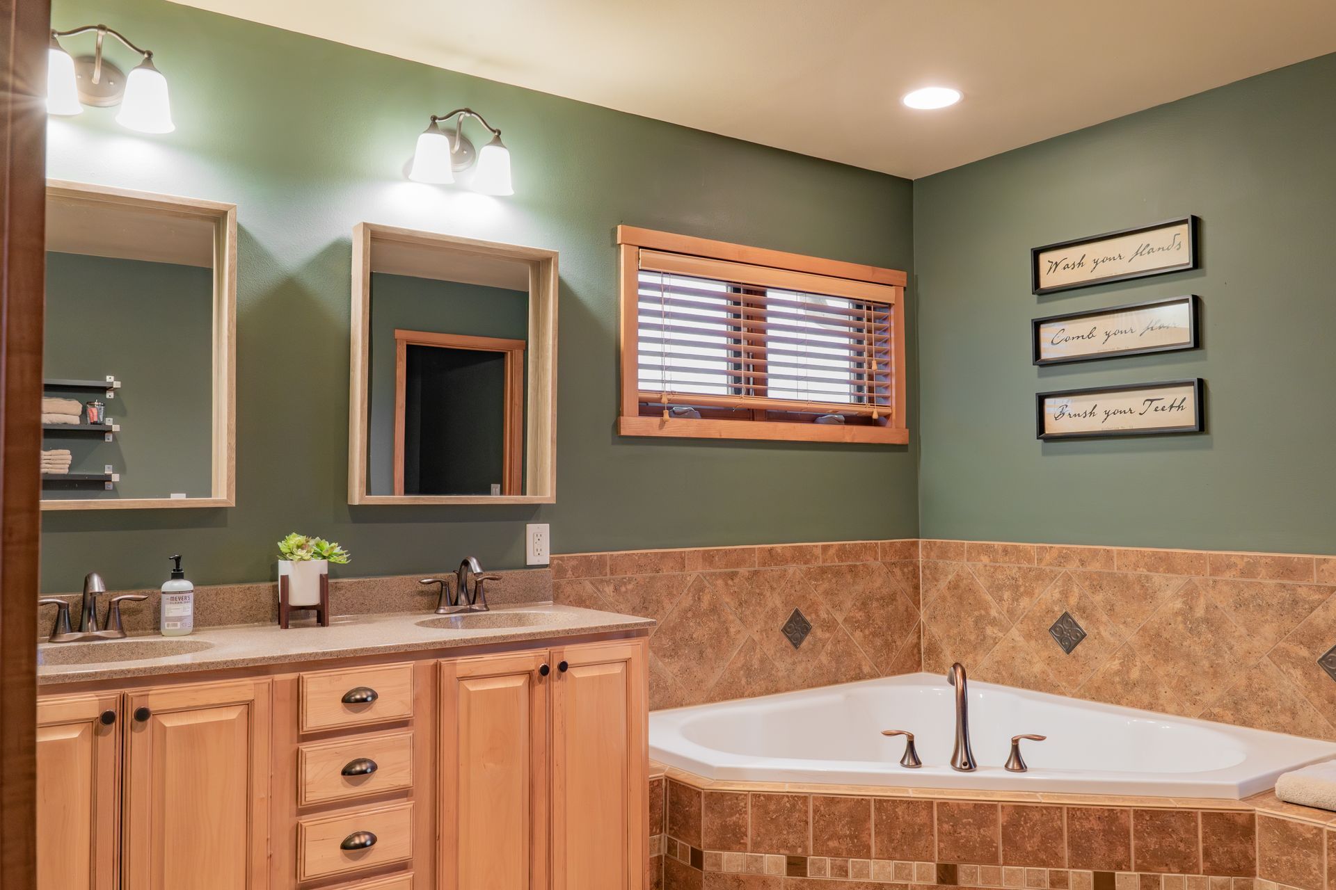 A bathroom with two sinks and a jacuzzi tub.