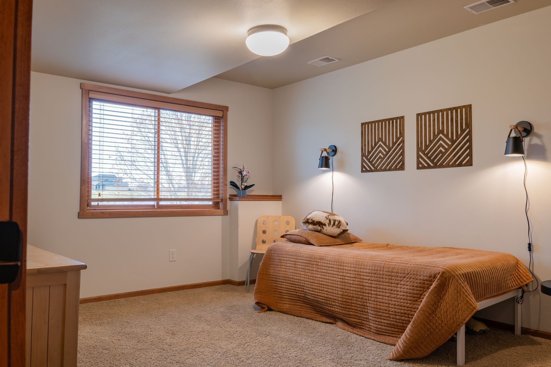 A bedroom with a single bed and a window.