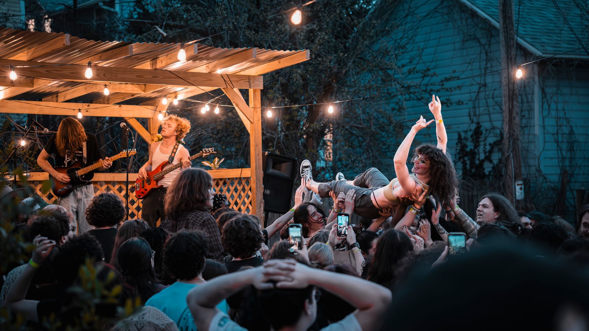 A woman is being lifted in the air by a crowd of people at a concert.