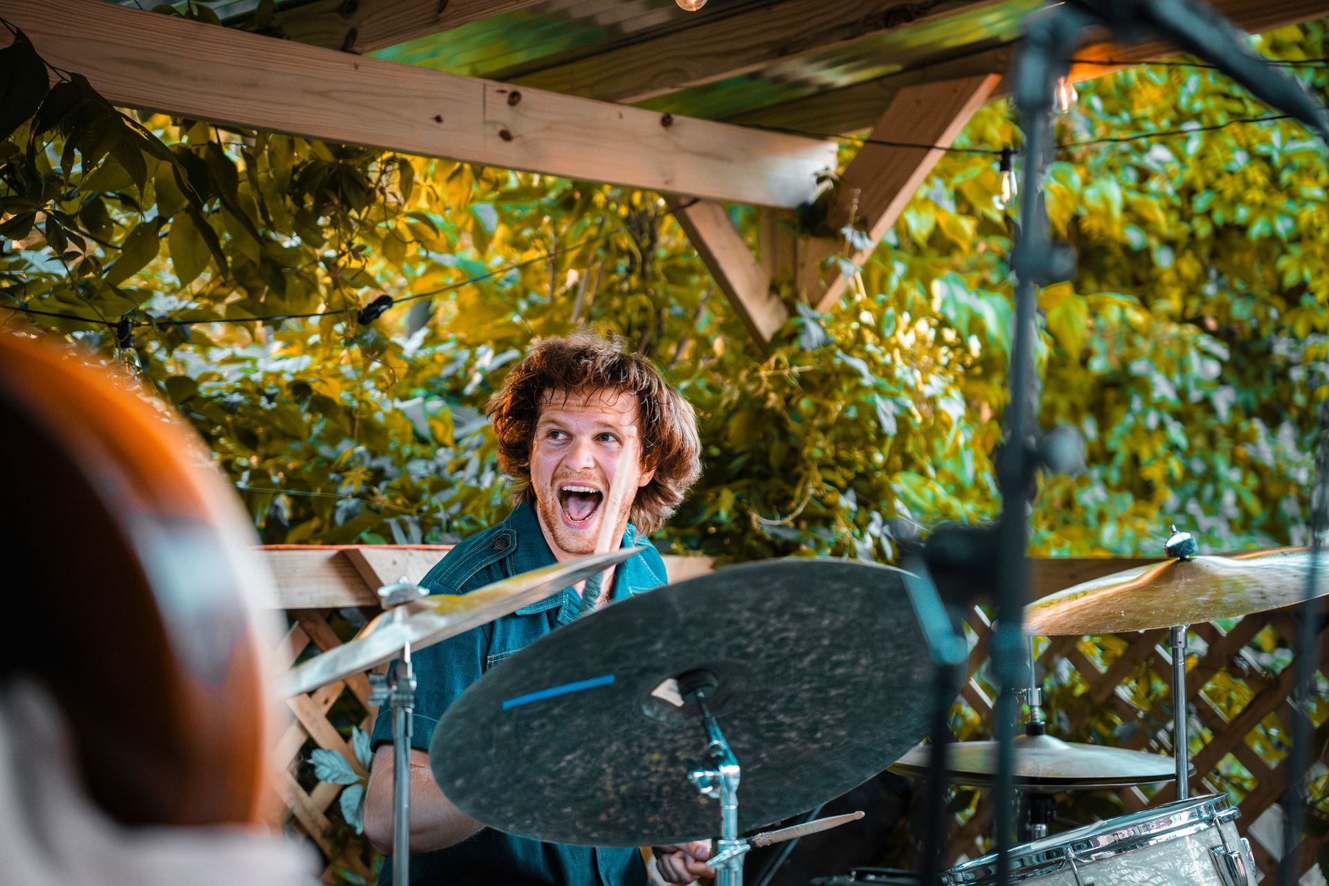 A young man is playing drums in front of a microphone.