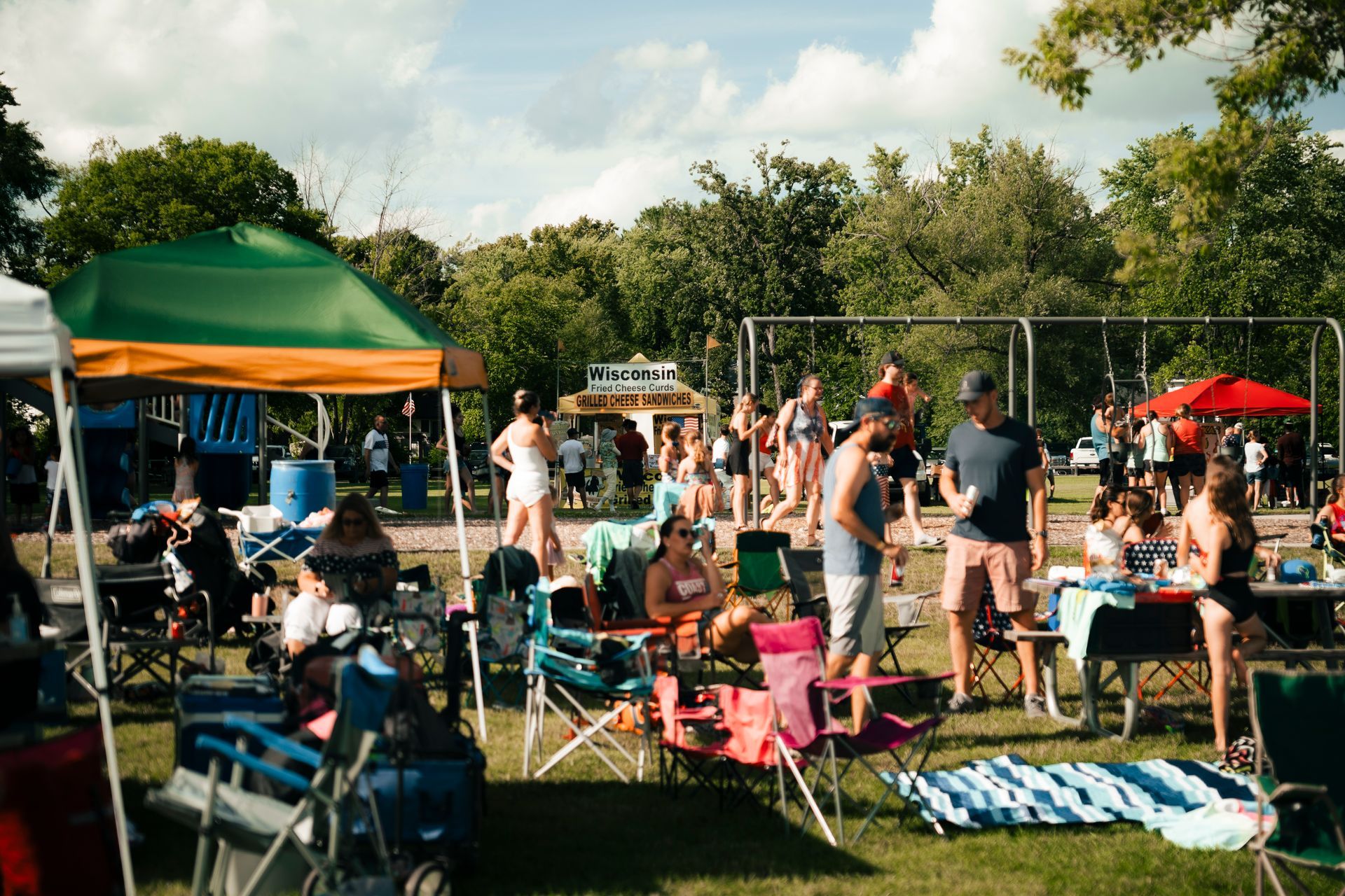 A group of people are sitting in chairs in a park.