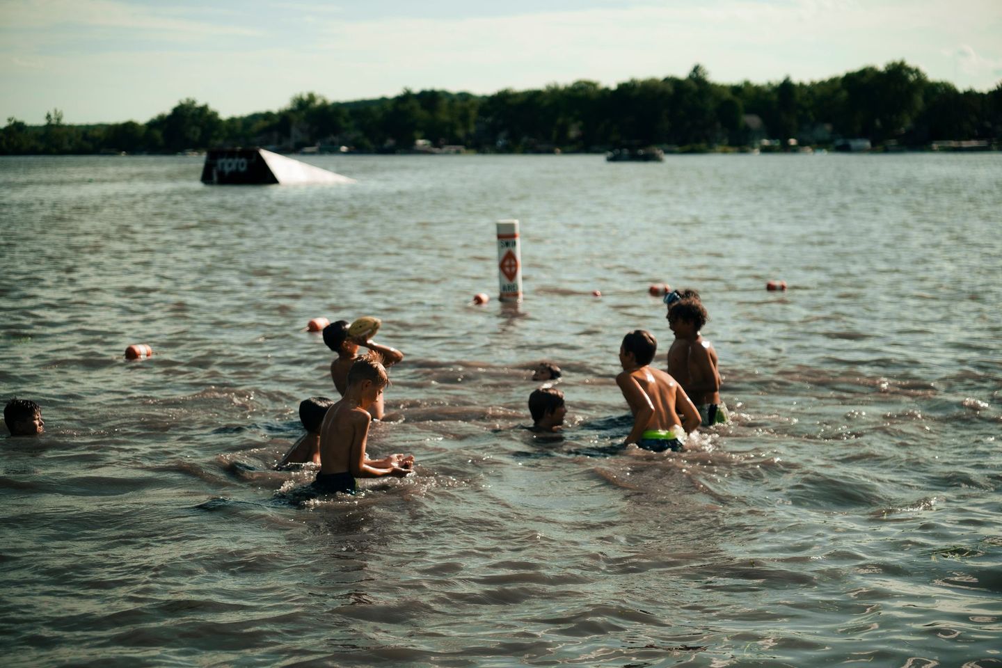 A group of people are swimming in a lake.