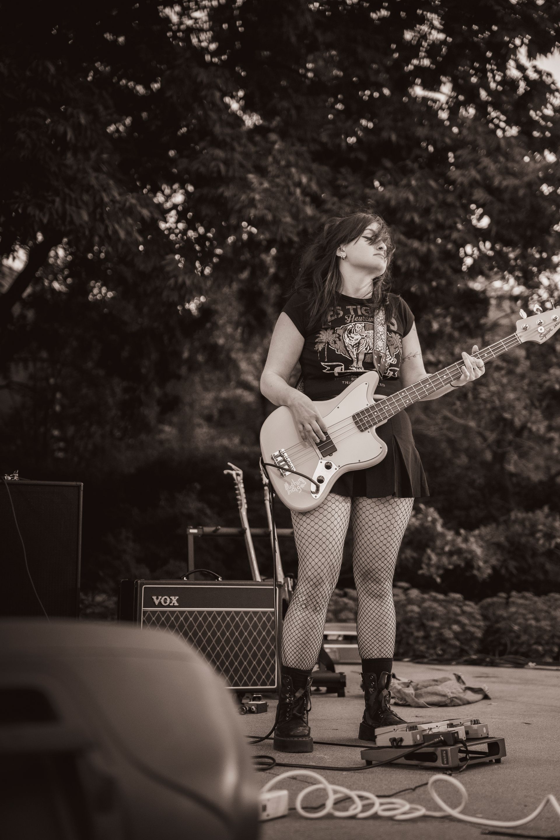 A woman is playing a guitar in a black and white photo