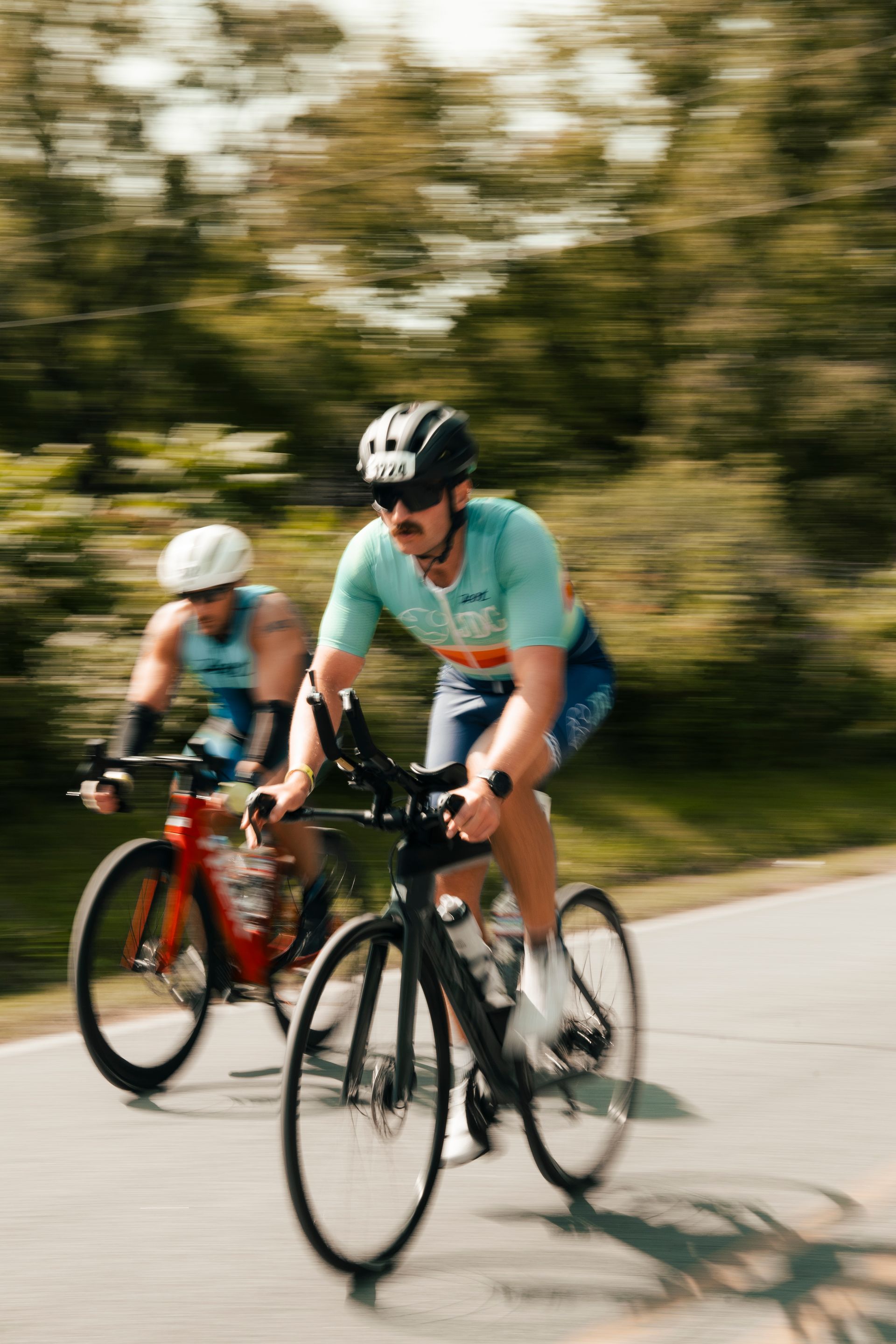 Two men are riding bicycles down a road.