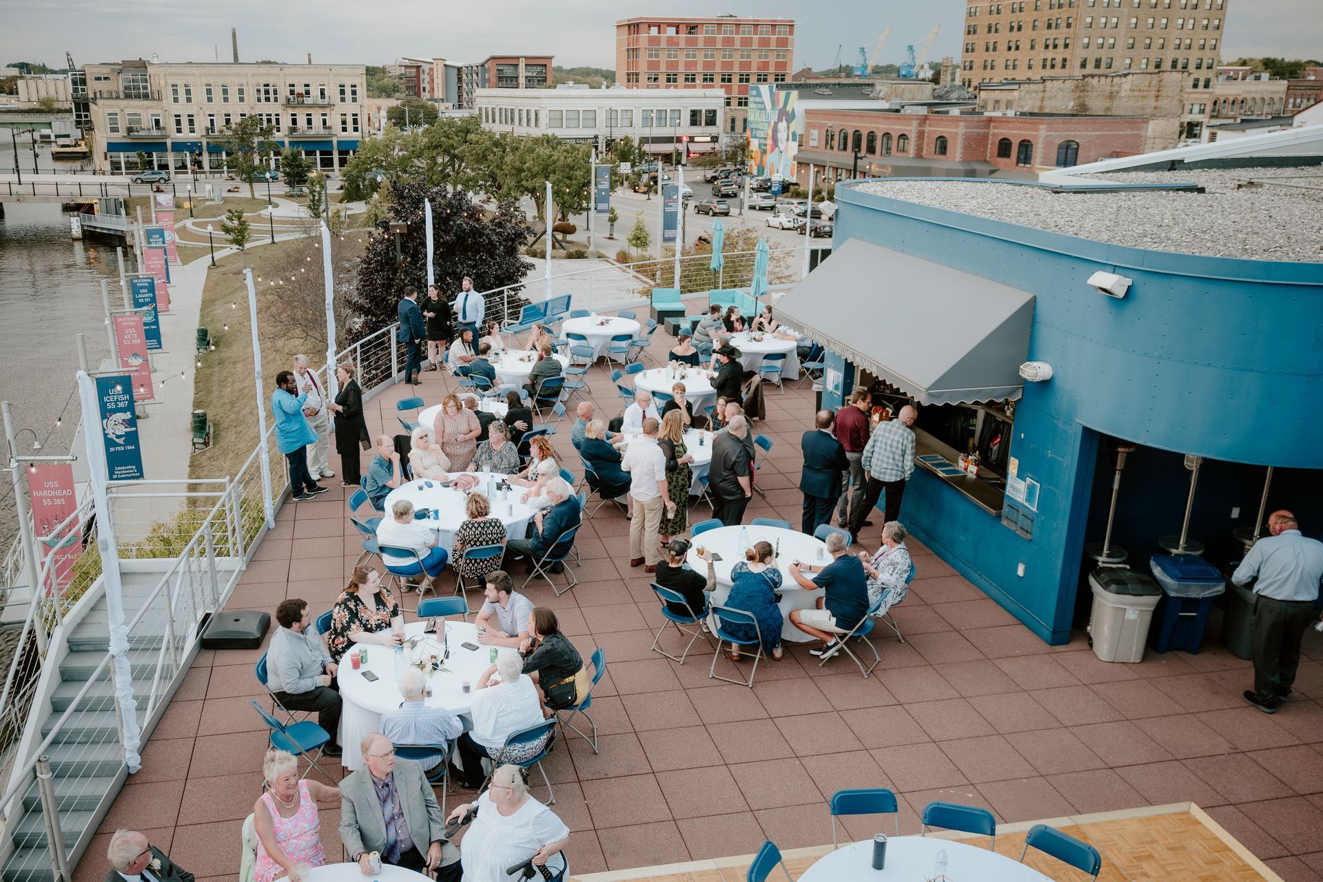 A group of people are sitting at tables on the roof of a building.