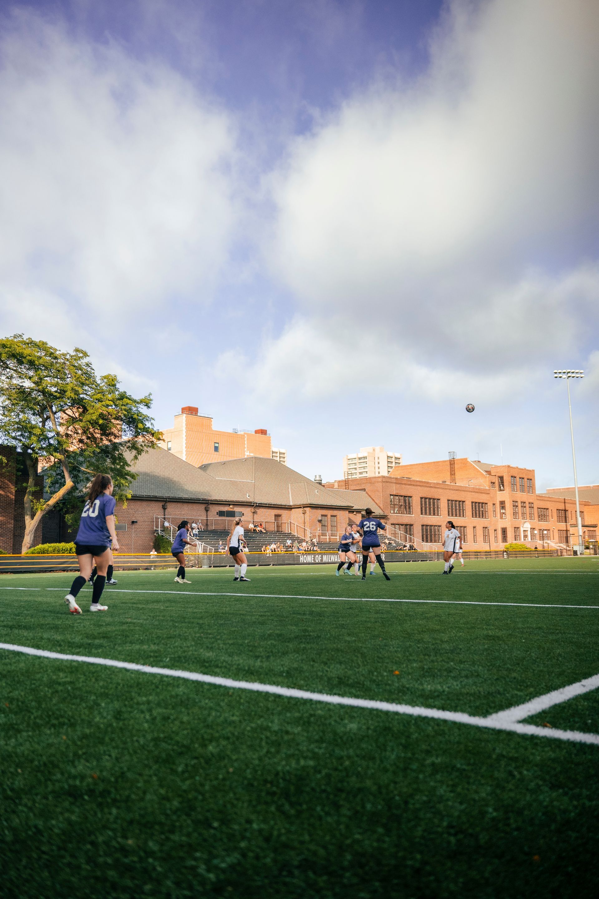 A group of people are playing soccer on a field.