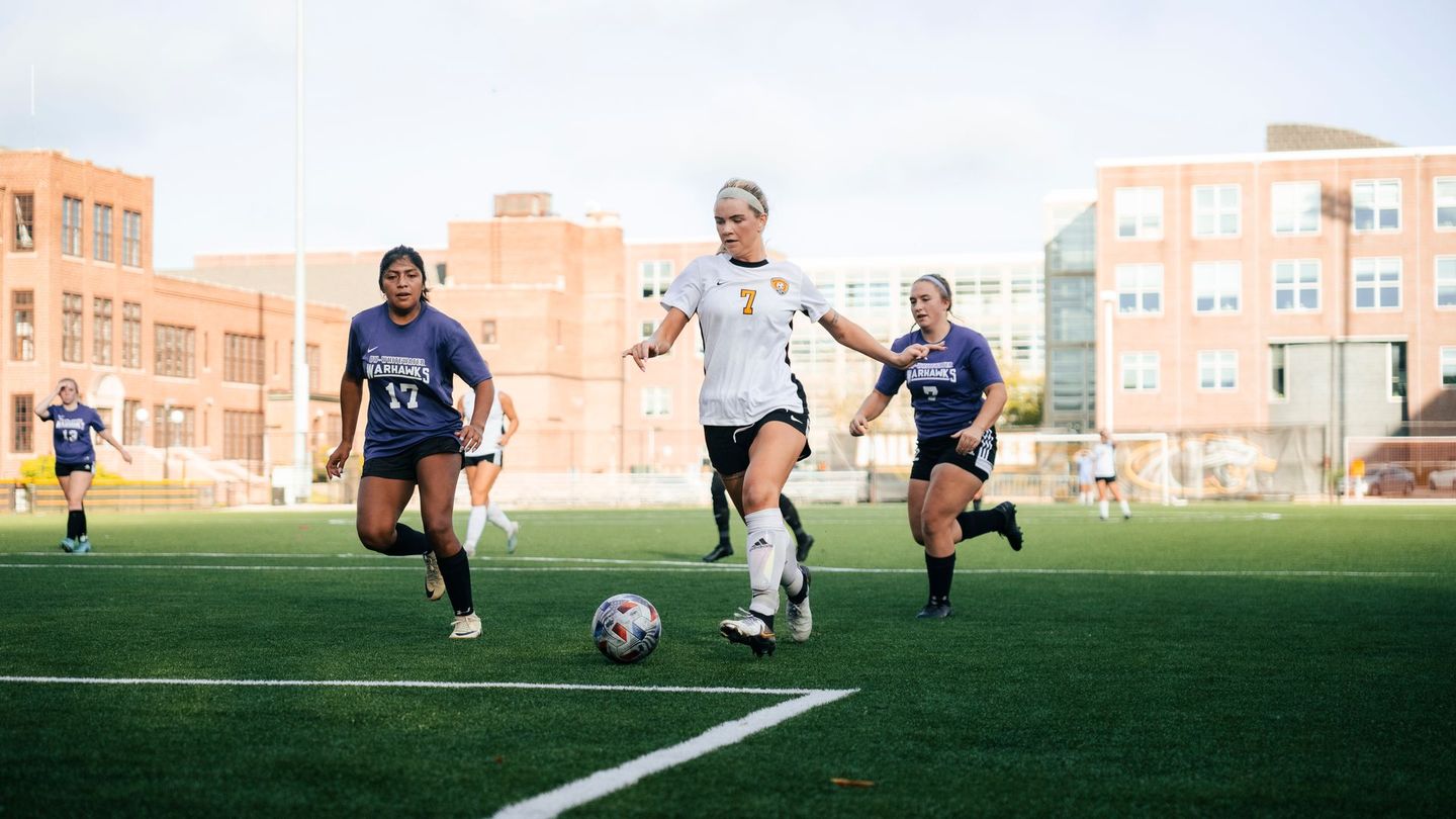 A group of women are playing soccer on a field.