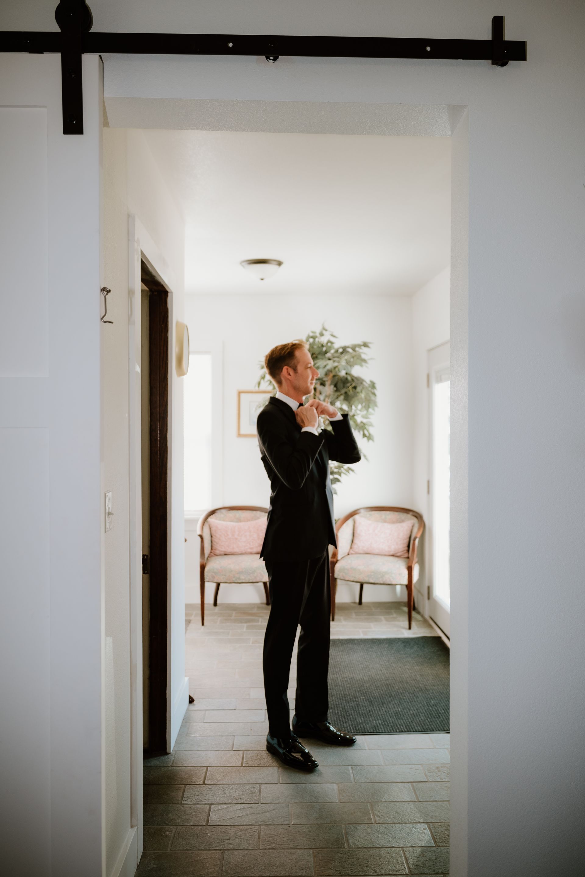 A man in a suit is standing in a hallway.