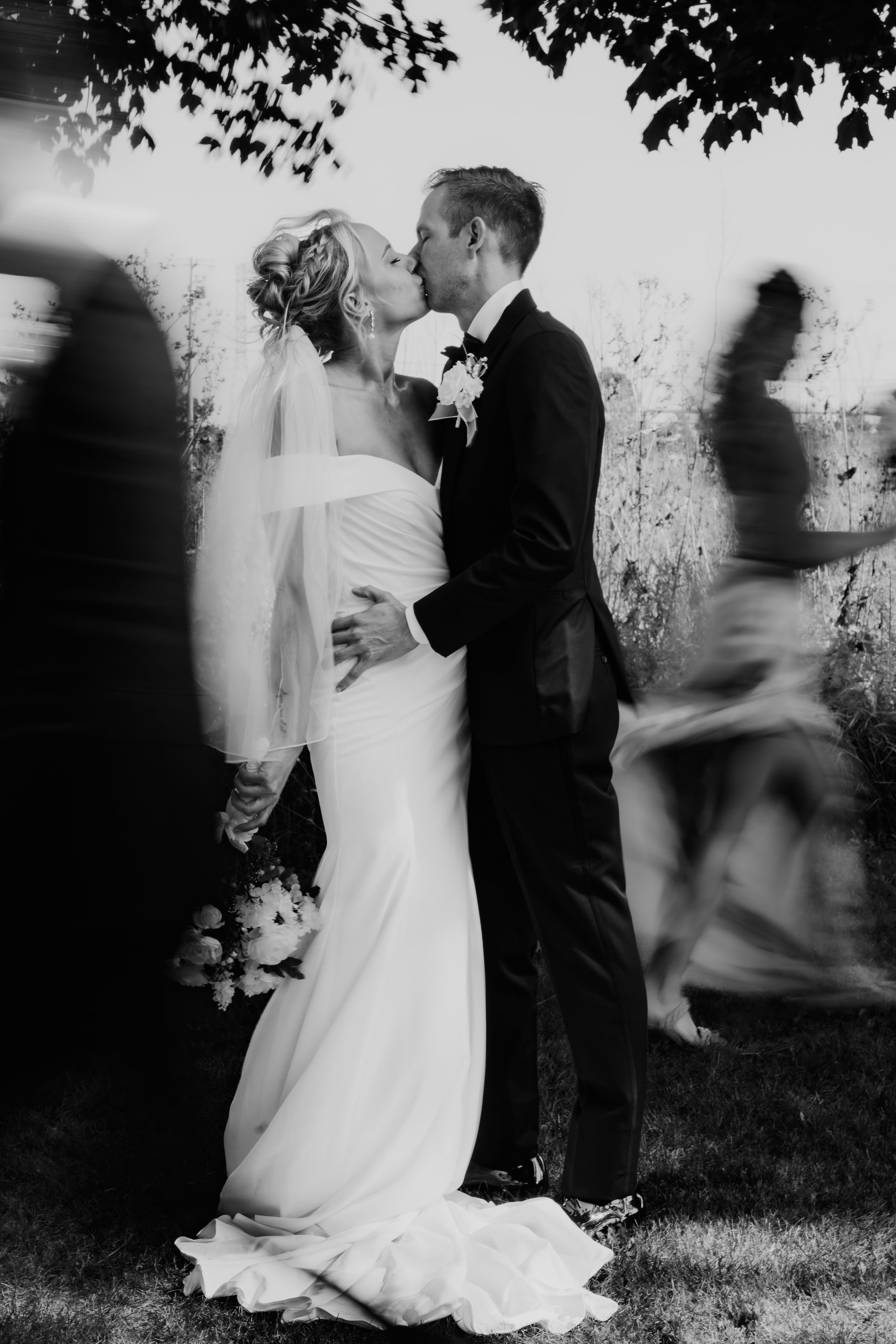 A bride and groom kissing in a black and white photo