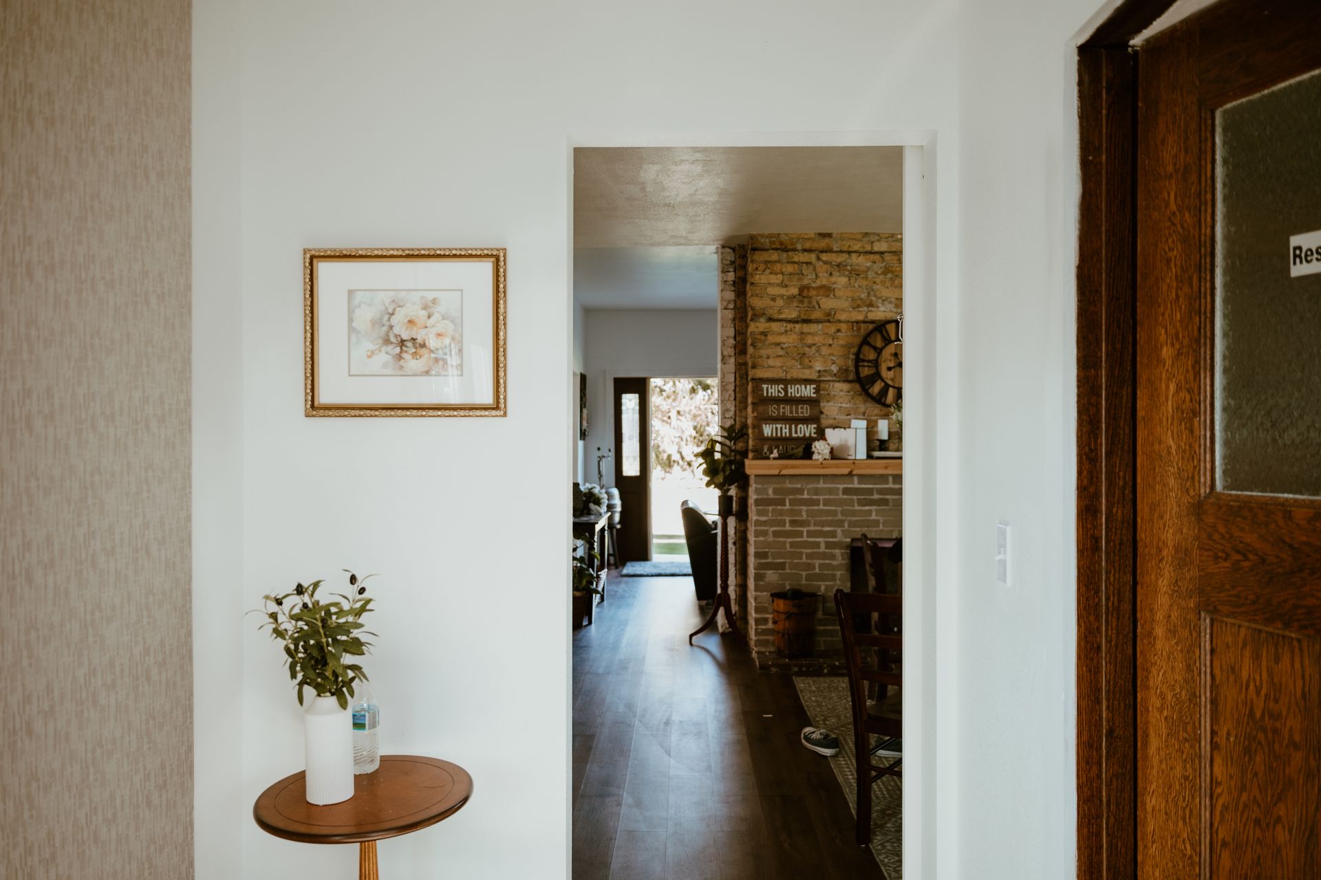 A hallway in a house with a table and a picture on the wall.