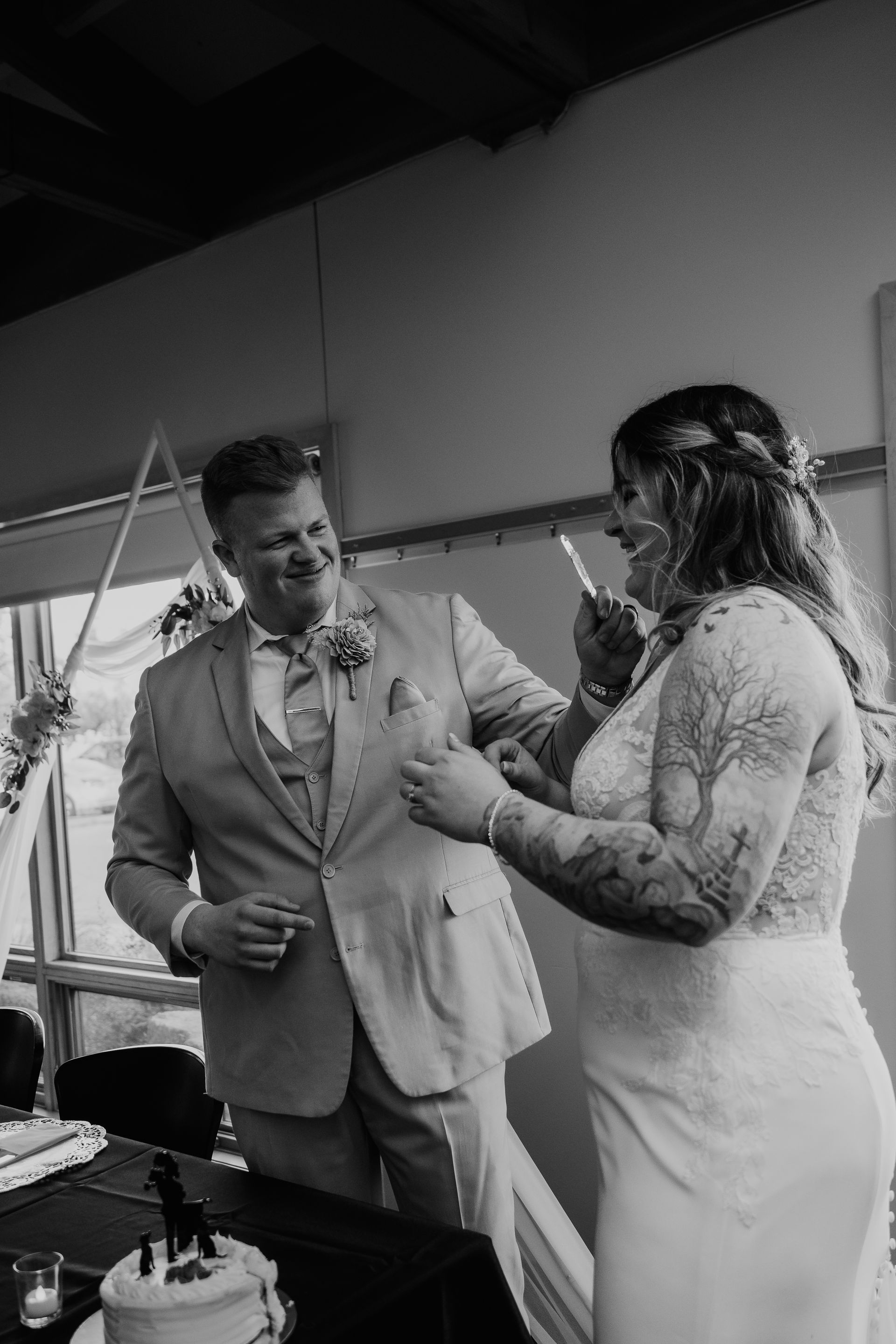 A bride and groom are cutting their wedding cake with knives.