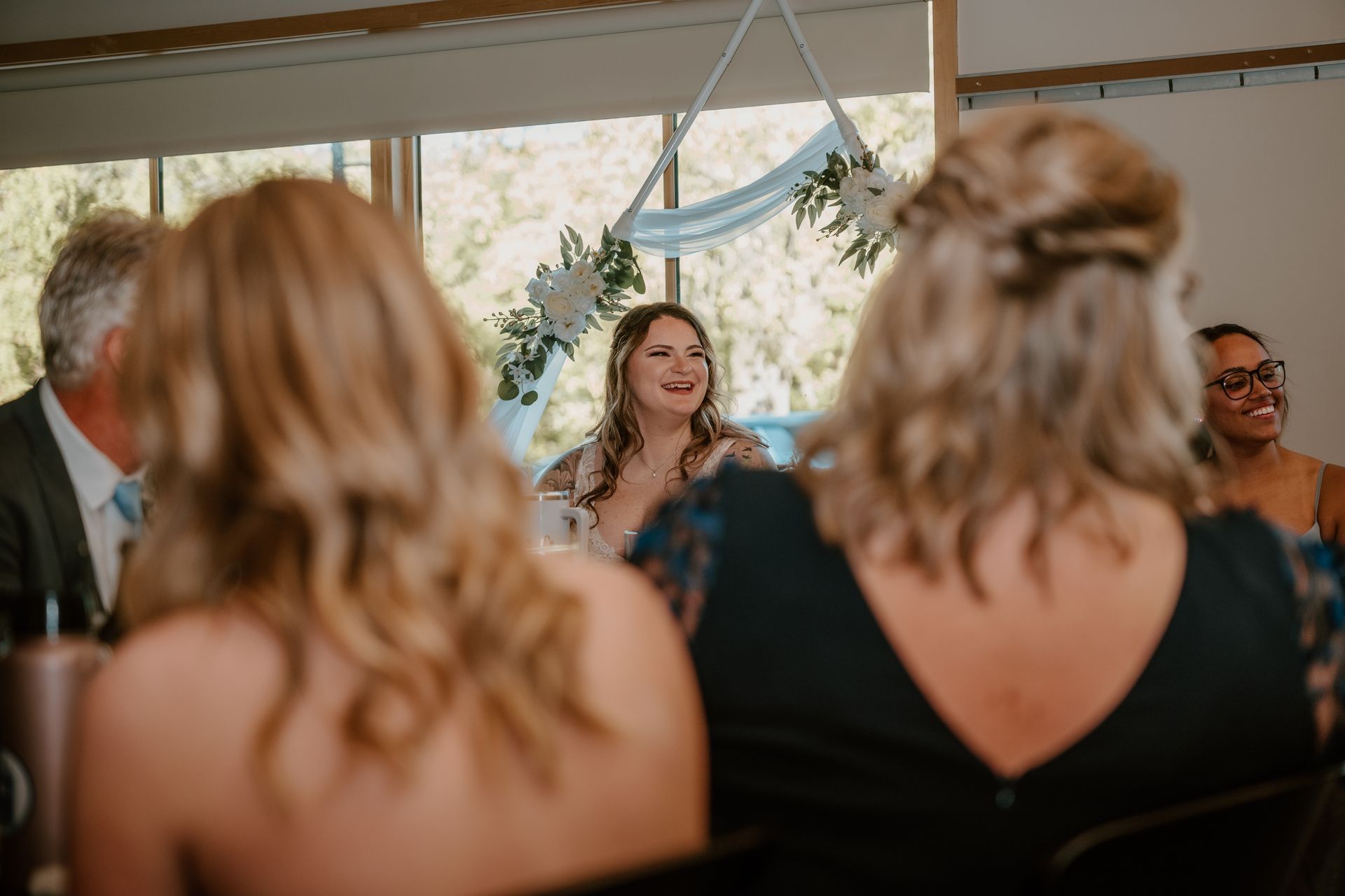 A group of women are sitting at a table at a wedding reception.