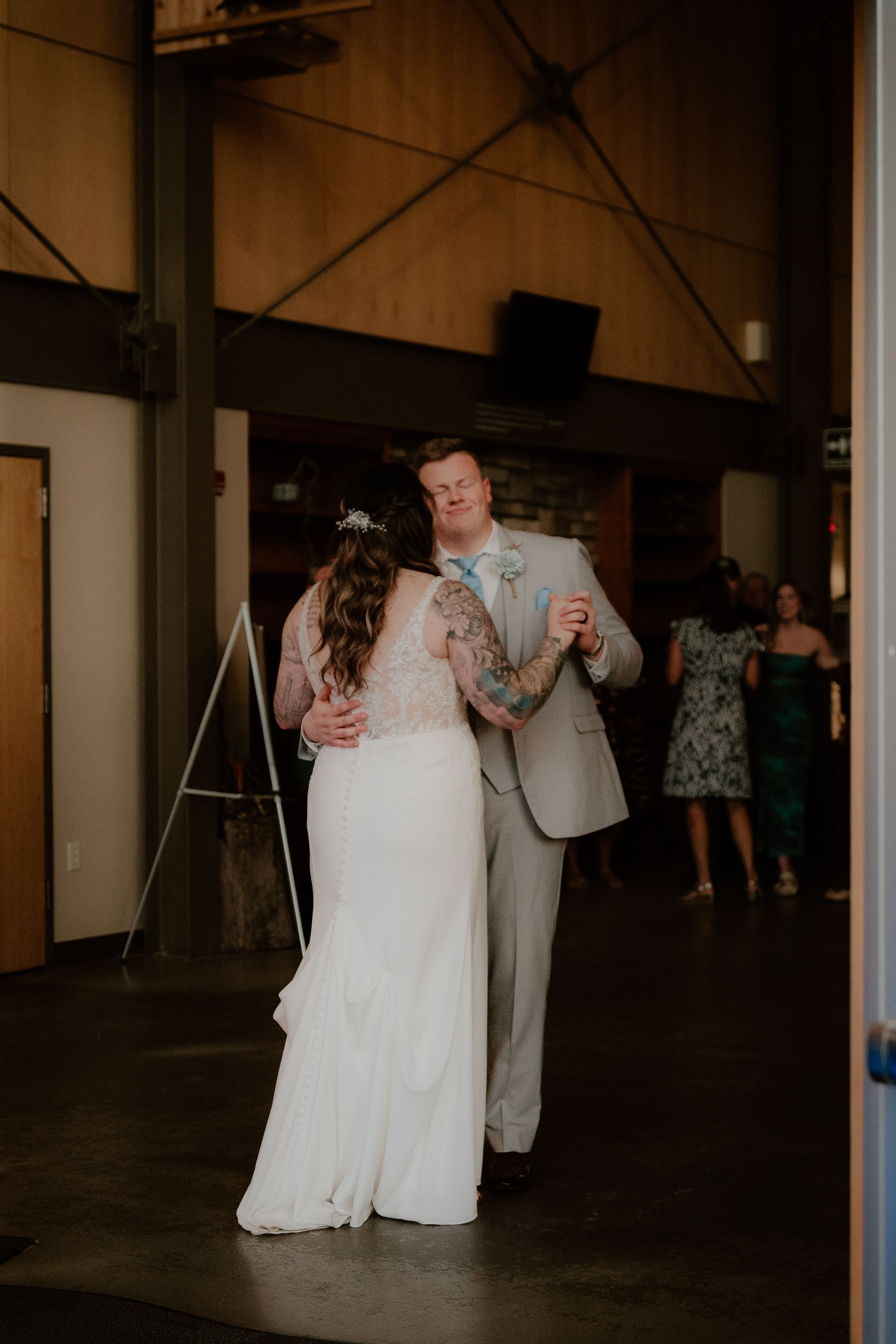 A bride and groom are dancing together at their wedding reception.