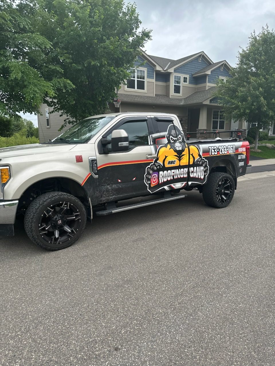 A white truck is parked in front of a house.