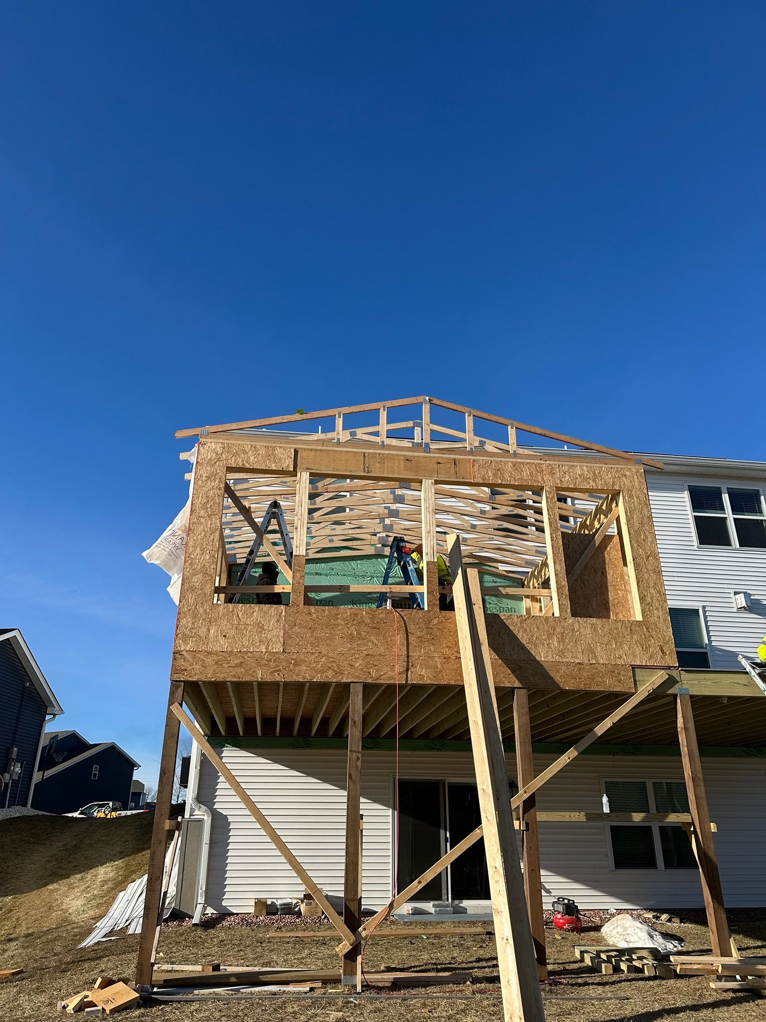 A house is being built on stilts with a deck.