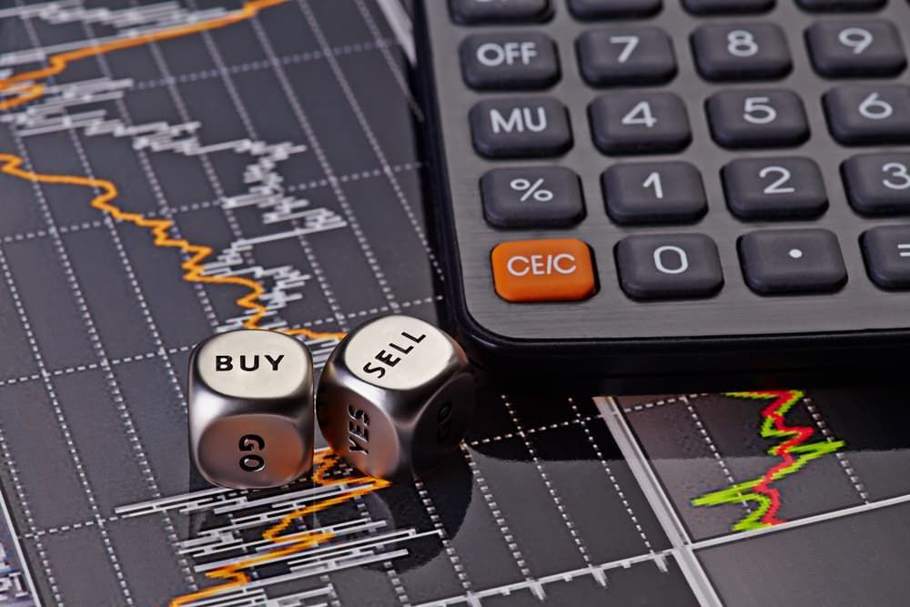 A Pair of Dice that Say Buy and Sell Next to A Calculator — Blue Orchid Accounting In Woongarrah, NSW