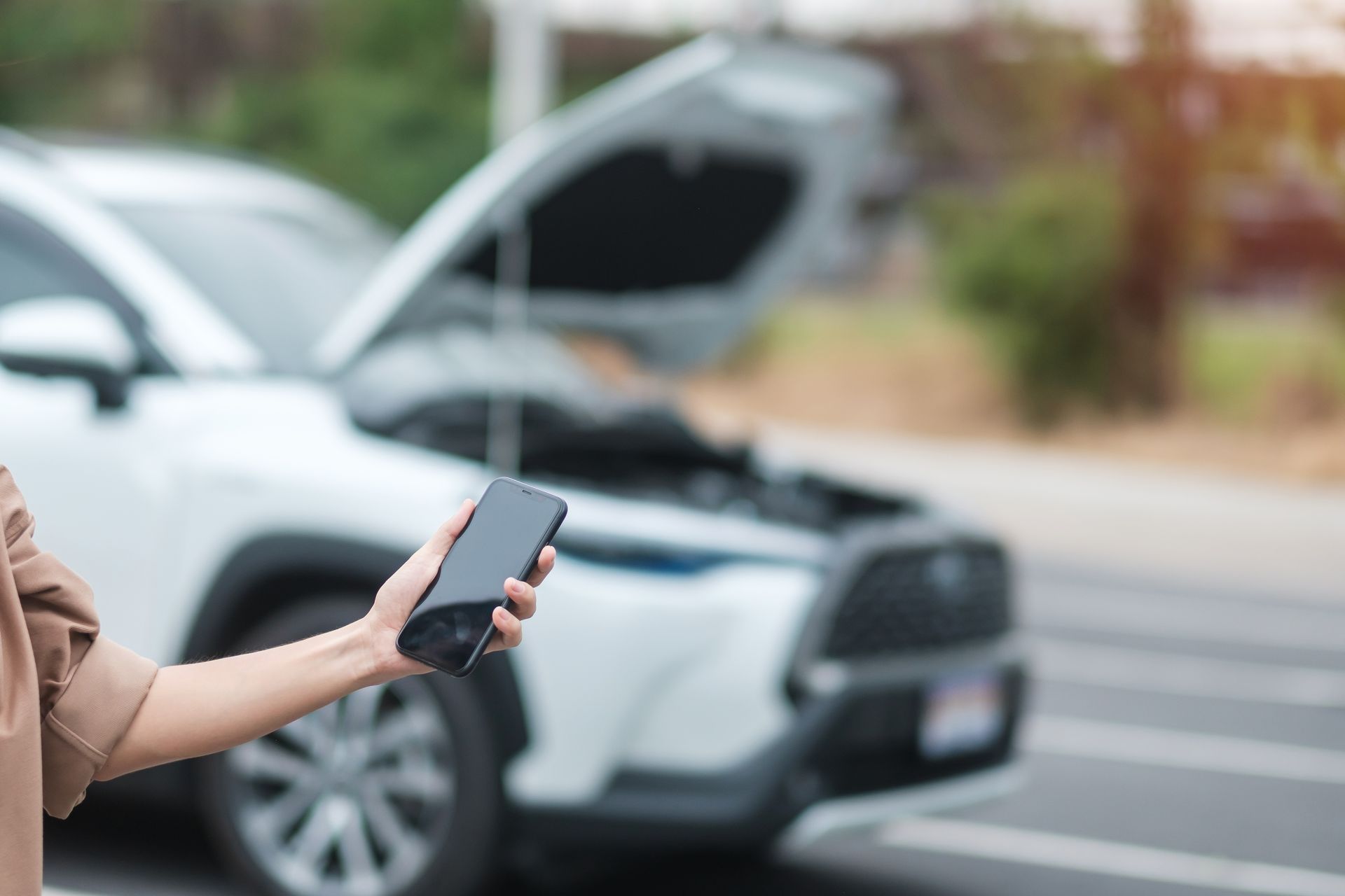 una macchina ferma per strada e un uomo che chiama l'autosoccorso